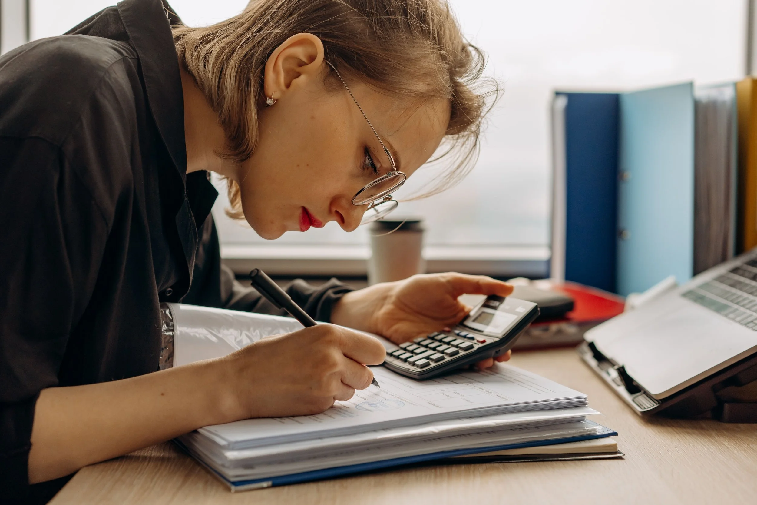 Bookkeeper reviewing financial reports for a Minneapolis small business owner using bookkeeping software in a modern office
