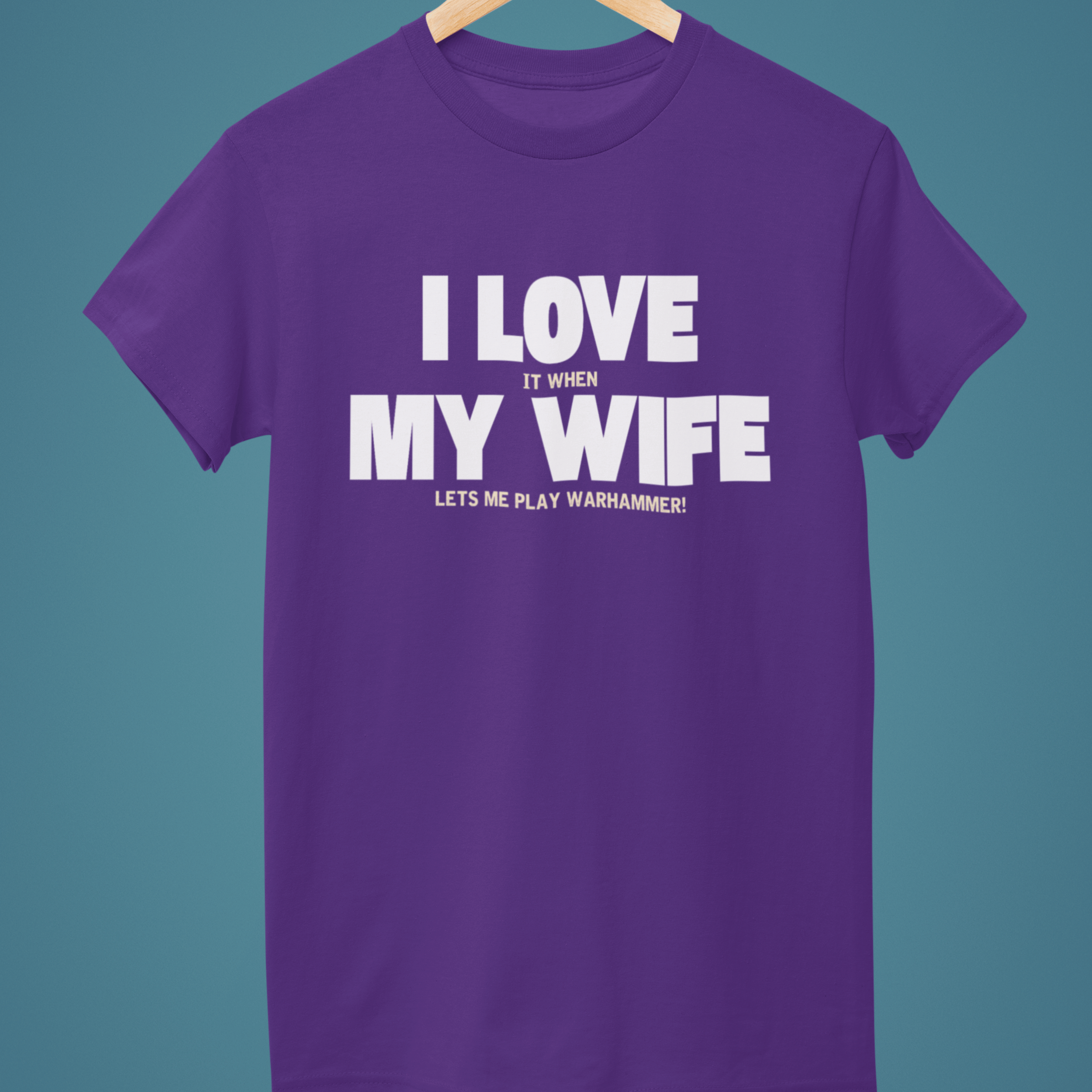 Purple Funny Warhammer t-shirt for husbands with wording "I love it when my wife lets me play warhammer!"