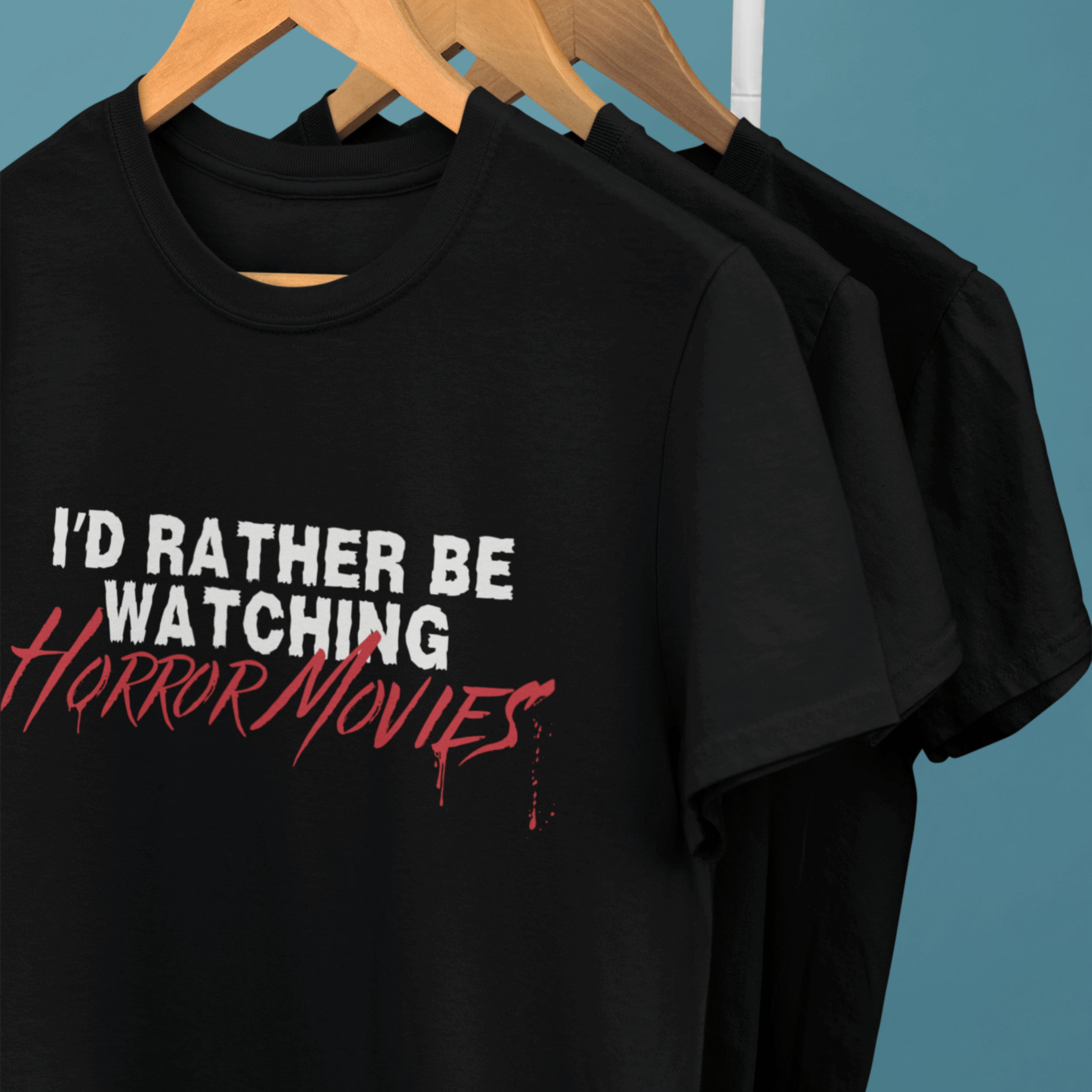 clothes rack of horror movie t-shirts with text "I'd rather be watching horror movies"