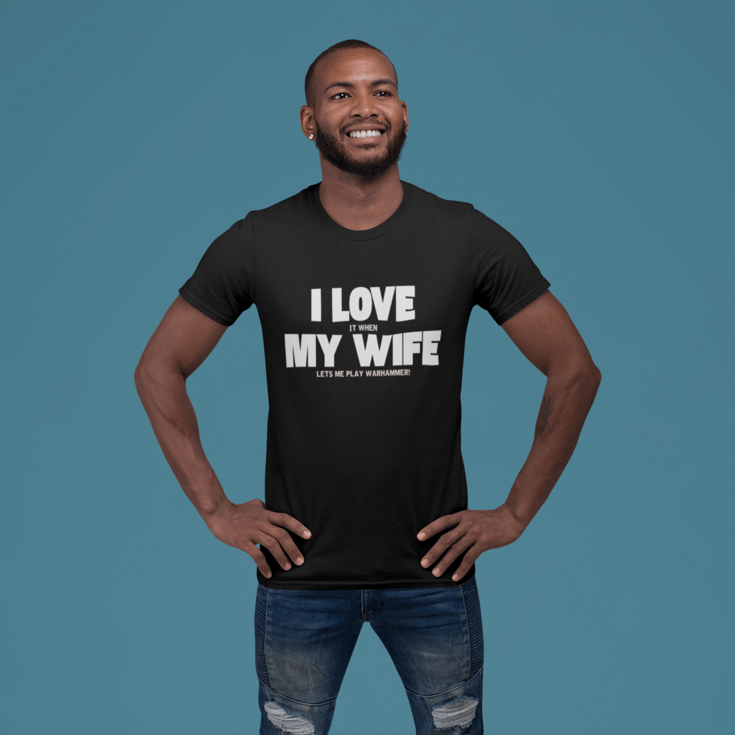 man smiling Funny Warhammer t-shirt for husbands with wording "I love it when my wife lets me play warhammer!"