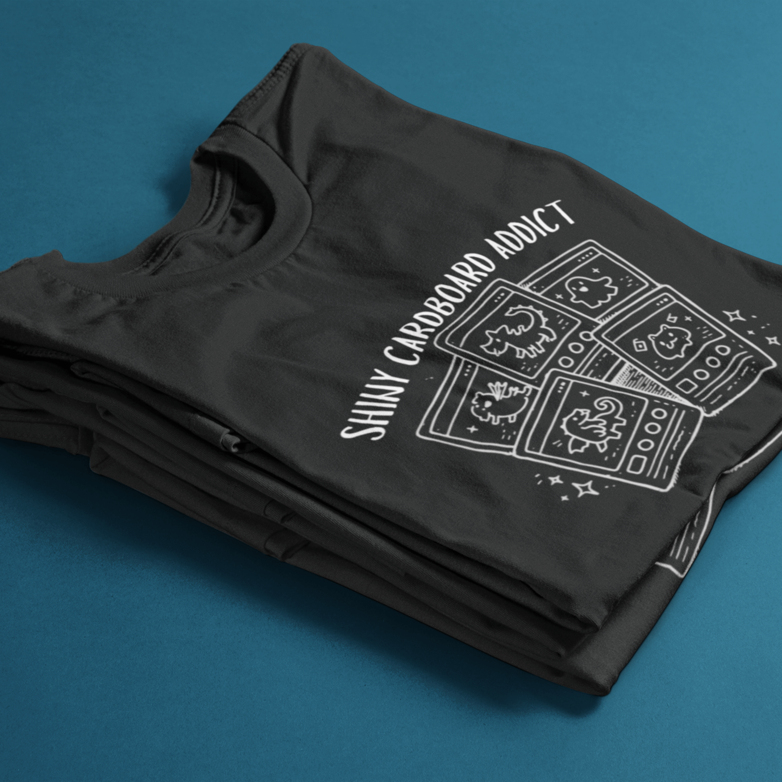 folded funny pokemon tshirt with "shiny cardboard addict" and derpy TCG cards