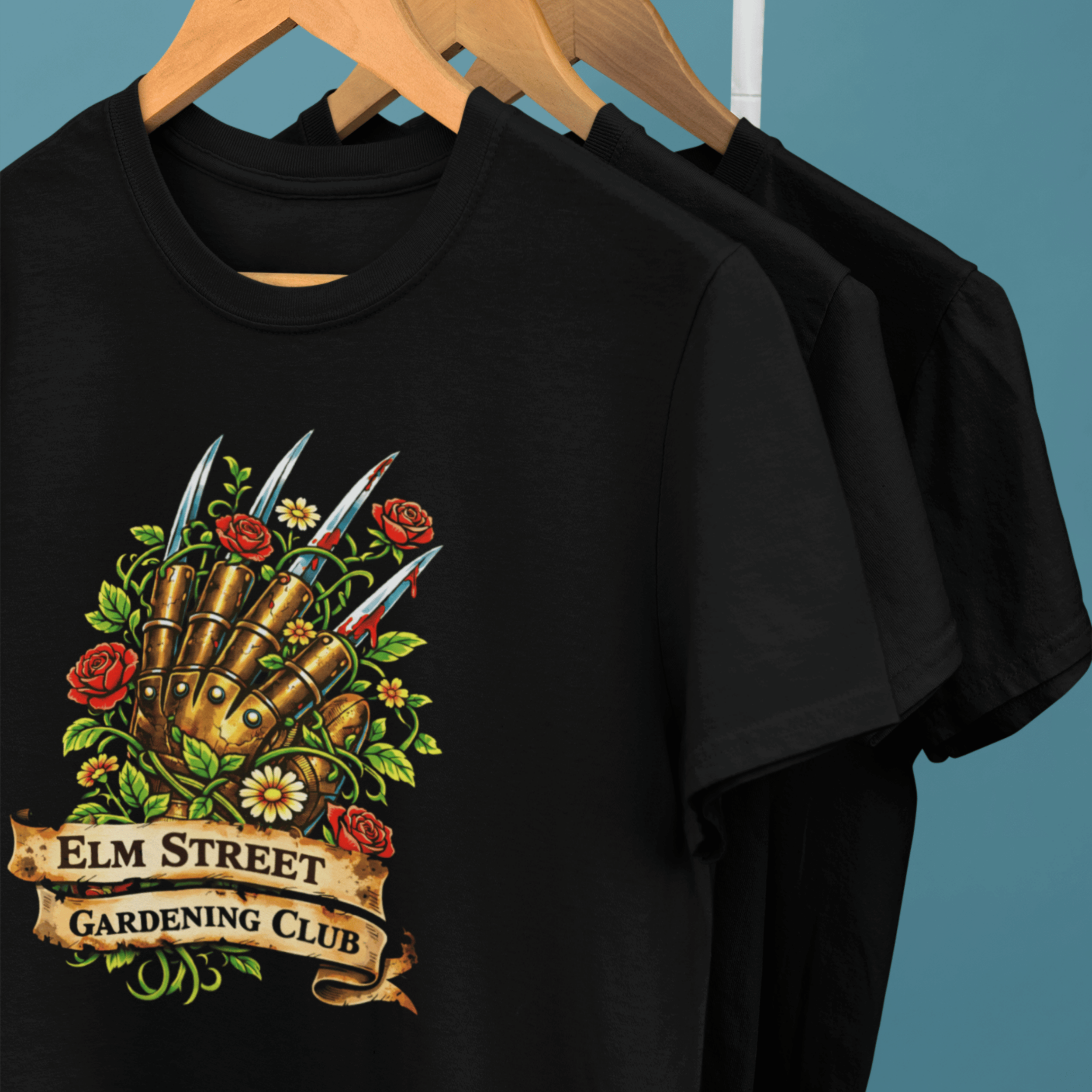 clothes rack of Nightmare on Elm Street t-shirts with freddy's claw and "elm street gardening club" sign