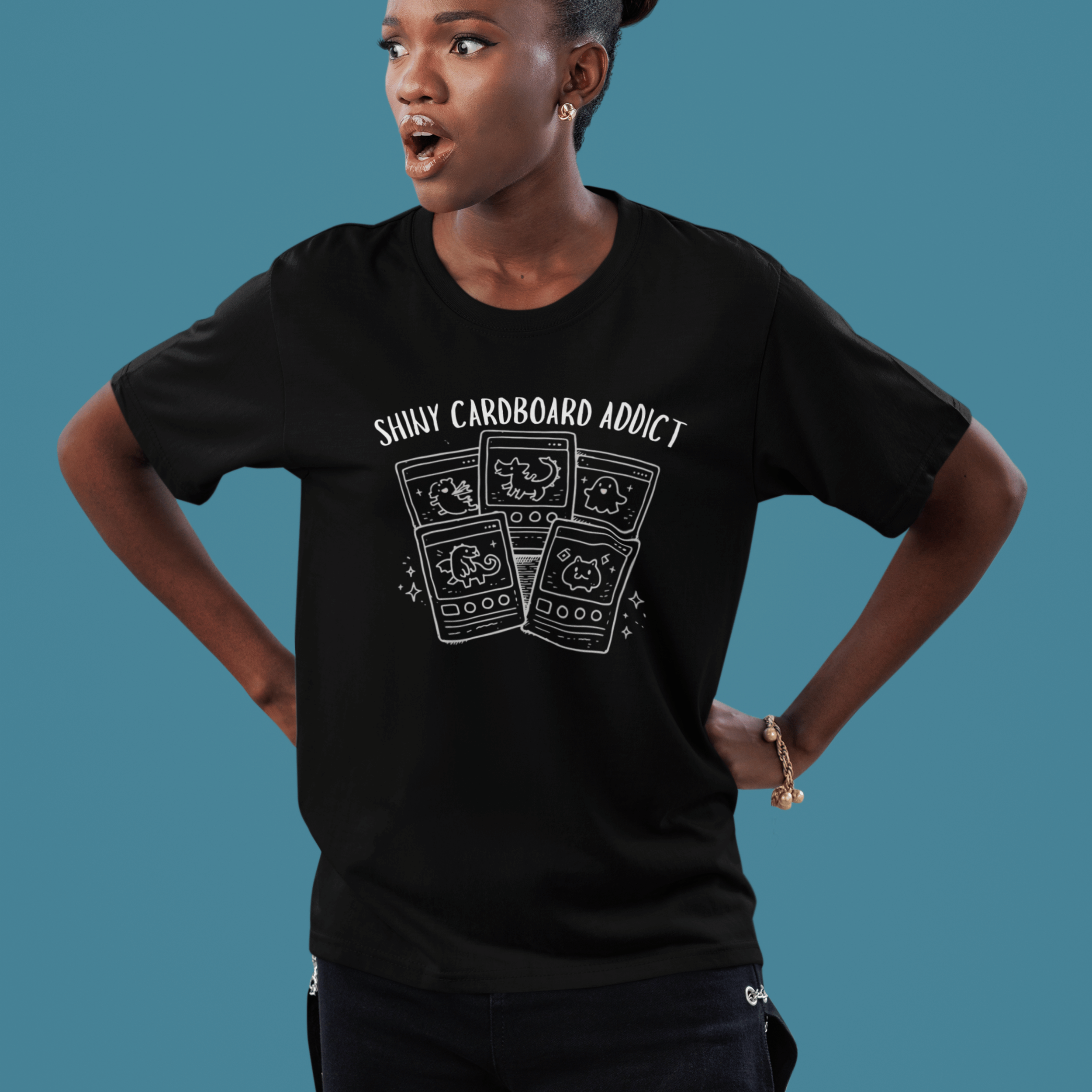 shocked woman wearing funny pokemon tshirt with "shiny cardboard addict" and derpy TCG cards