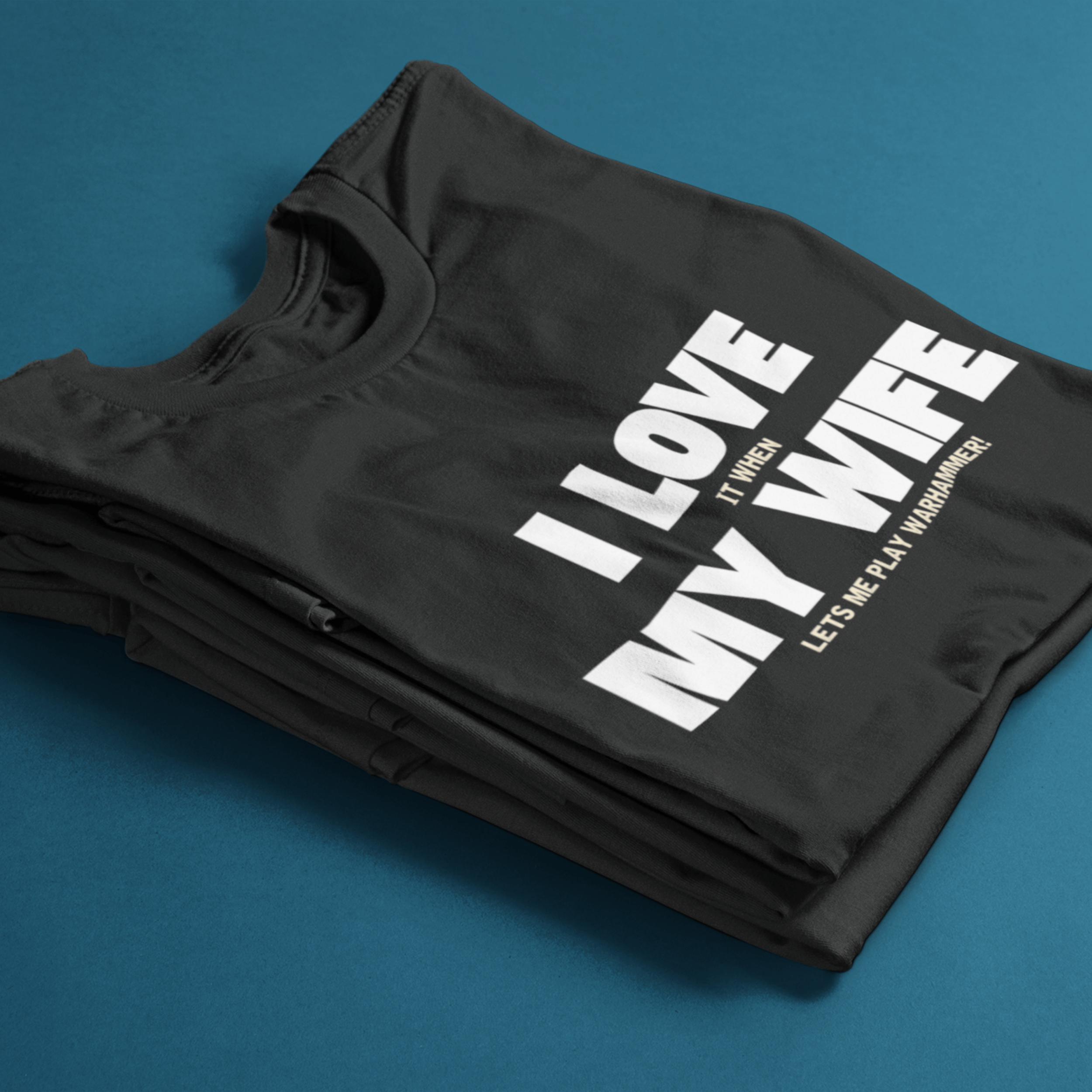 folded Funny Warhammer t-shirt for husbands with wording "I love it when my wife lets me play warhammer!"