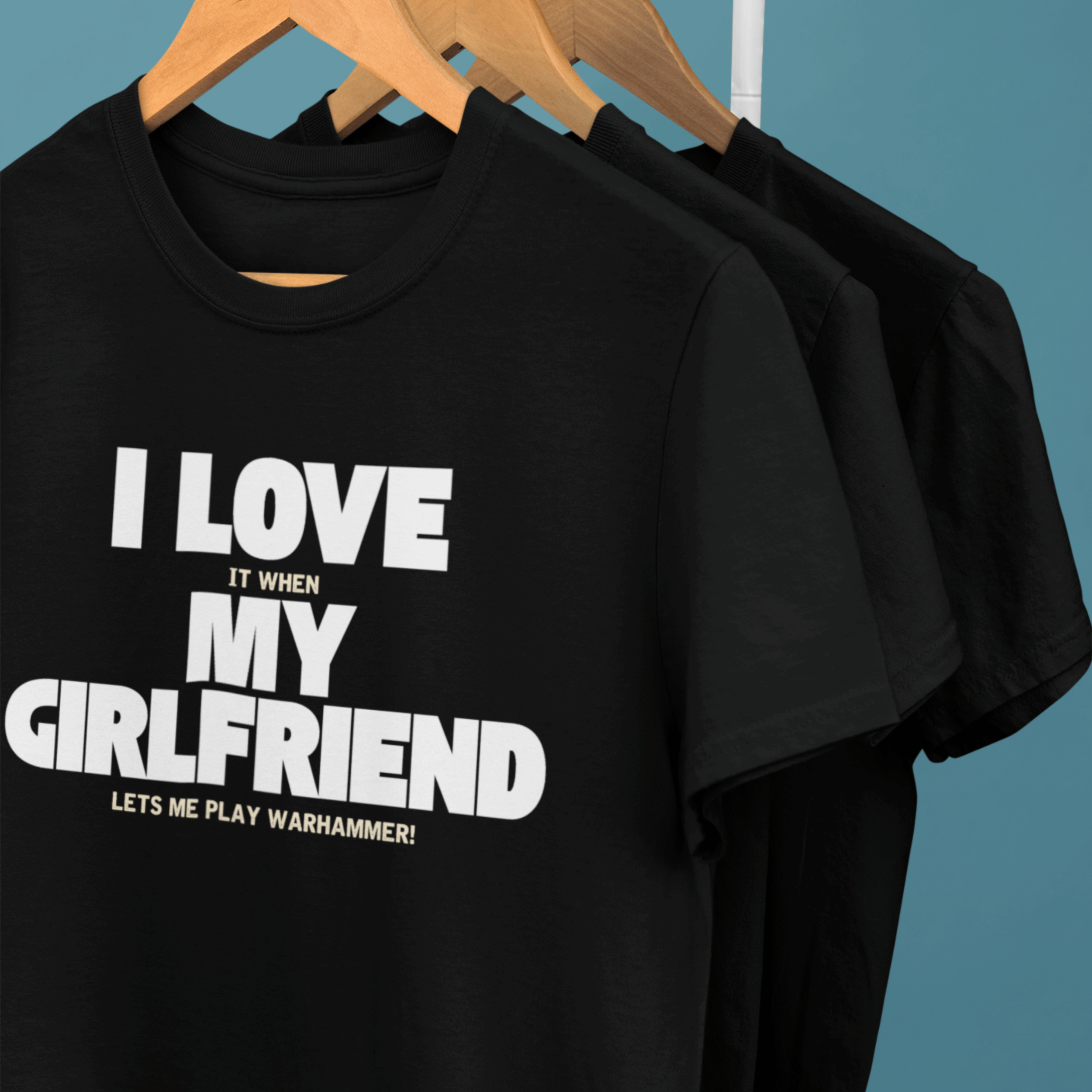 clothes rack of Funny warhammer t-shirts for boyfriend with slogan "I love it when my girlfriend lets me play warhammer!"