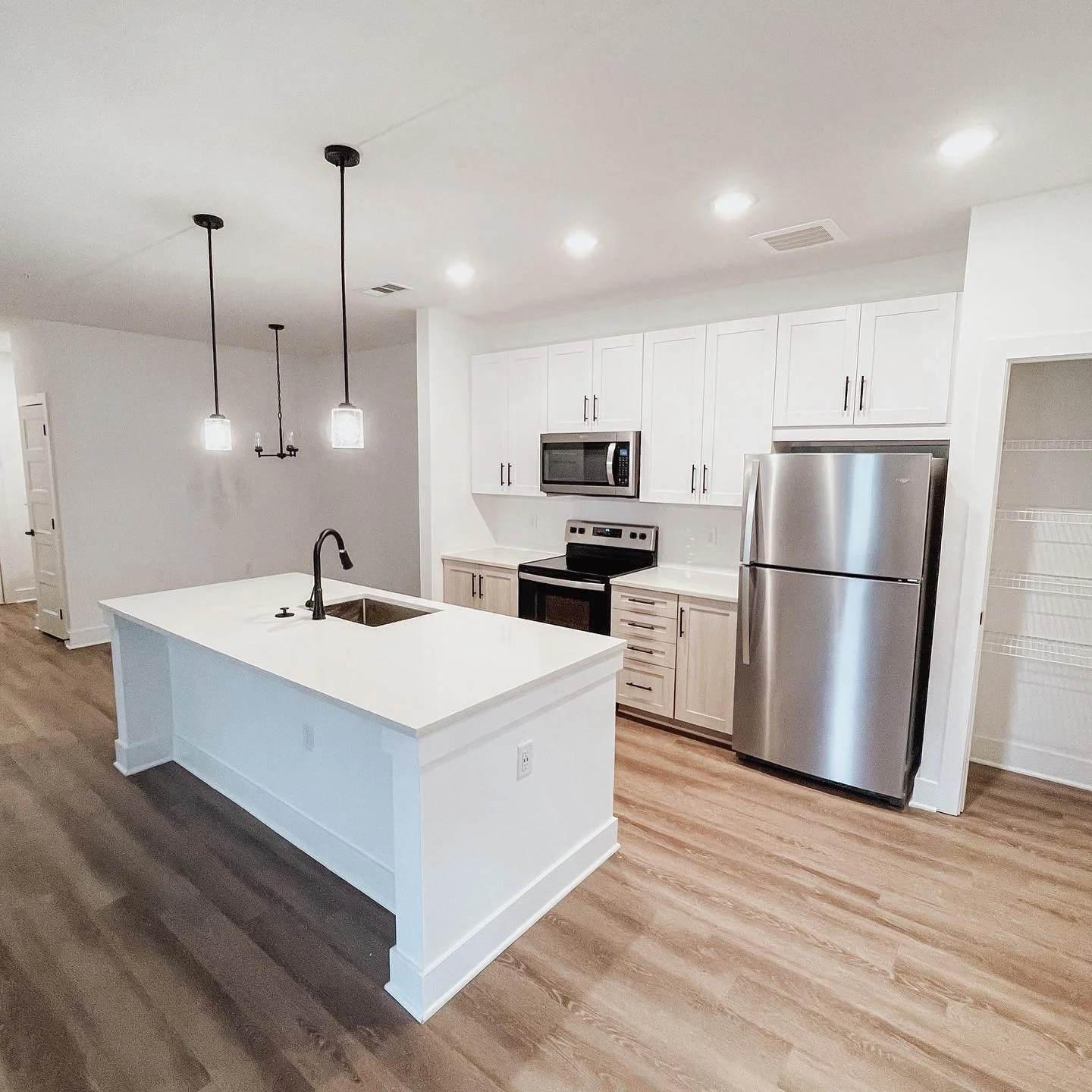 Fully furnished kitchen and island within The Glenn multifamily apartment complex - Auburn, AL