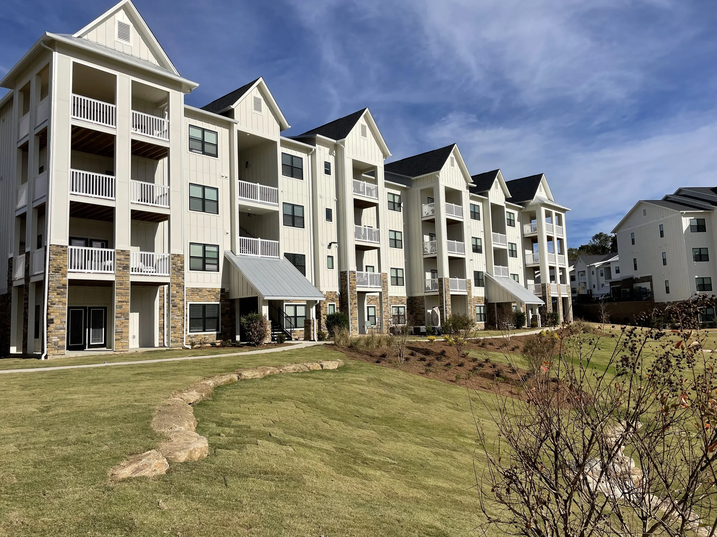 Low shot of several buildings and a walking path within The Glenn multifamily apartment complex - Auburn, AL