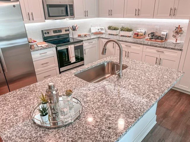 Kitchen island, fridge, oven and cabinetry within a typical unit in the Courtney Ridge multifamily apartment complex - Charlotte, NC