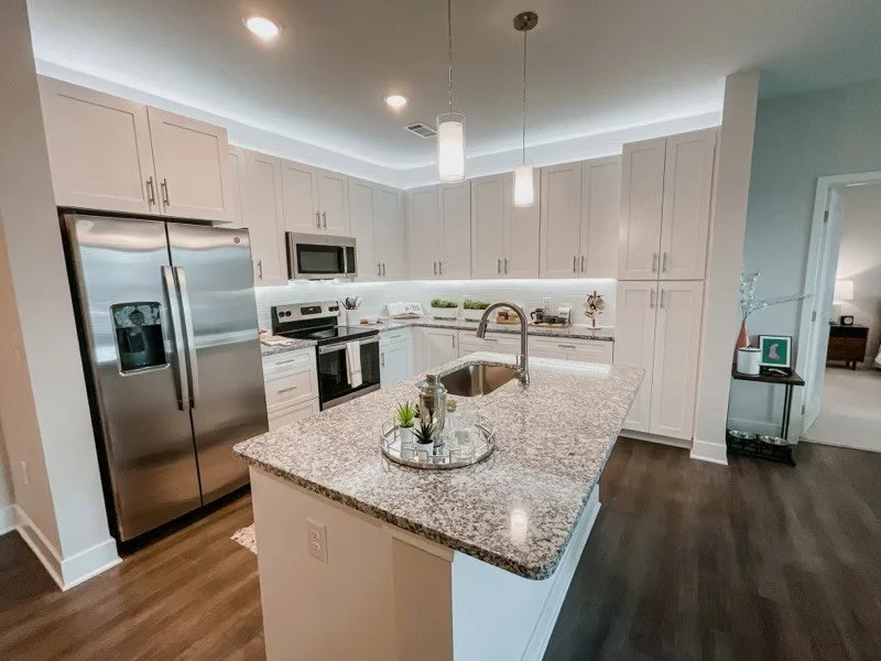 Courtney Ridge multifamily apartment complex typical kitchen and dining area with a small accent table and hardwood floors.