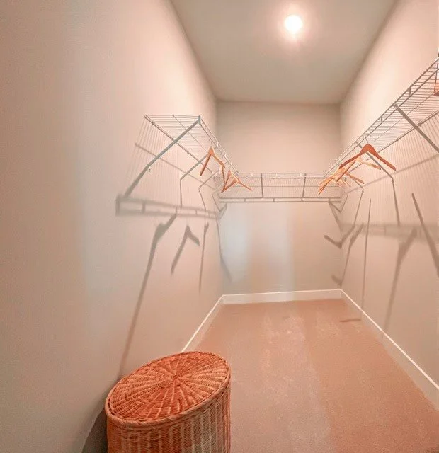 Courtney Ridge multifamily apartment complex typical walk-in closet with an overhead light and a small footstool.