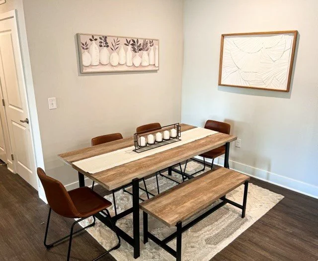 Dining area with some wall art and a bench within a typical unit in the Courtney Ridge multifamily apartment complex - Charlotte, NC