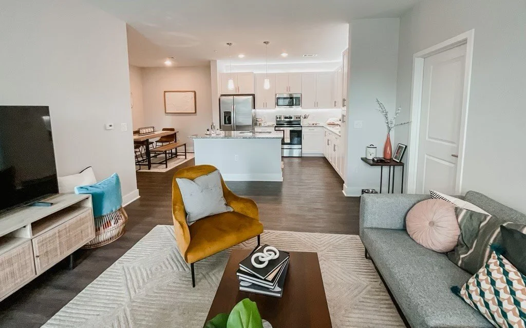 Typical living room with kitchen and dining area in the background within the Courtney Ridge multifamily apartment complex - Charlotte, NC