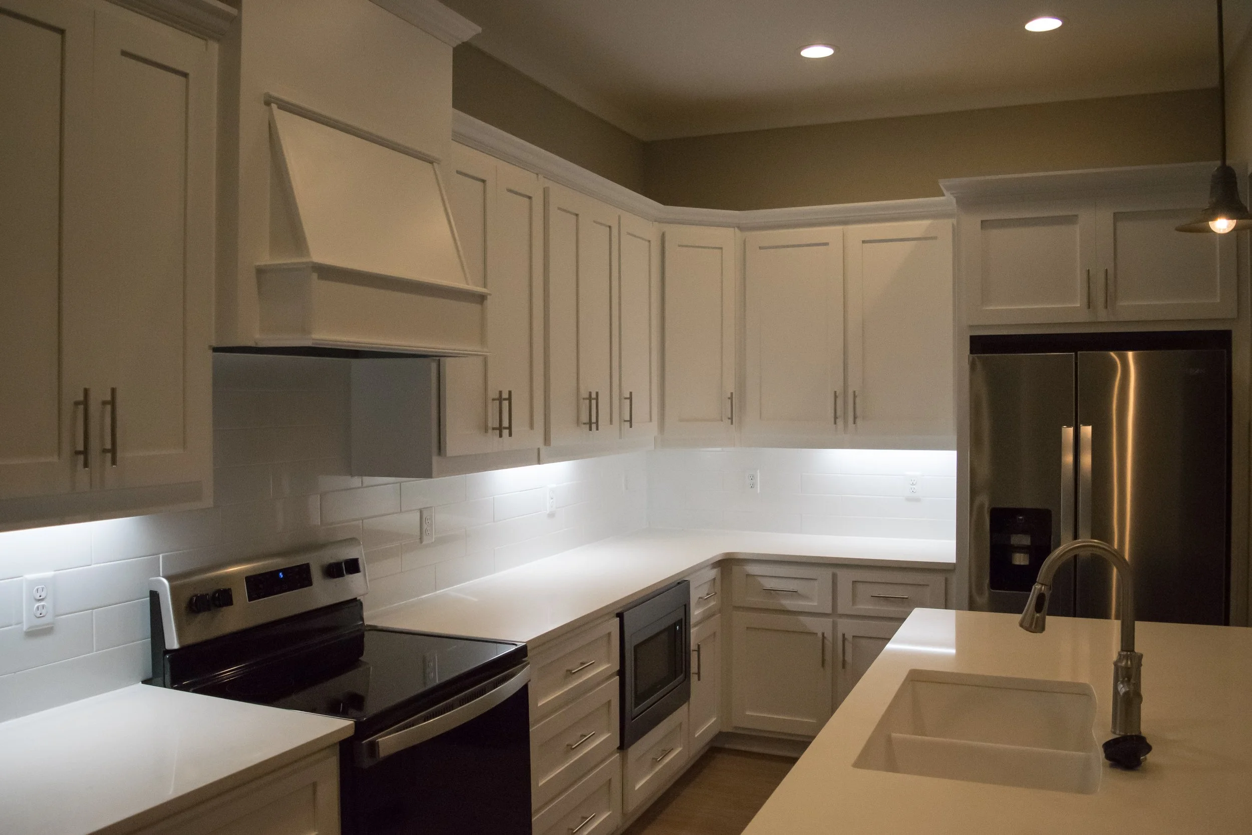 Kitchen area with island, oven and refrigerator in the Old Town Townhomes multifamily townhome complex - Columbus, GA