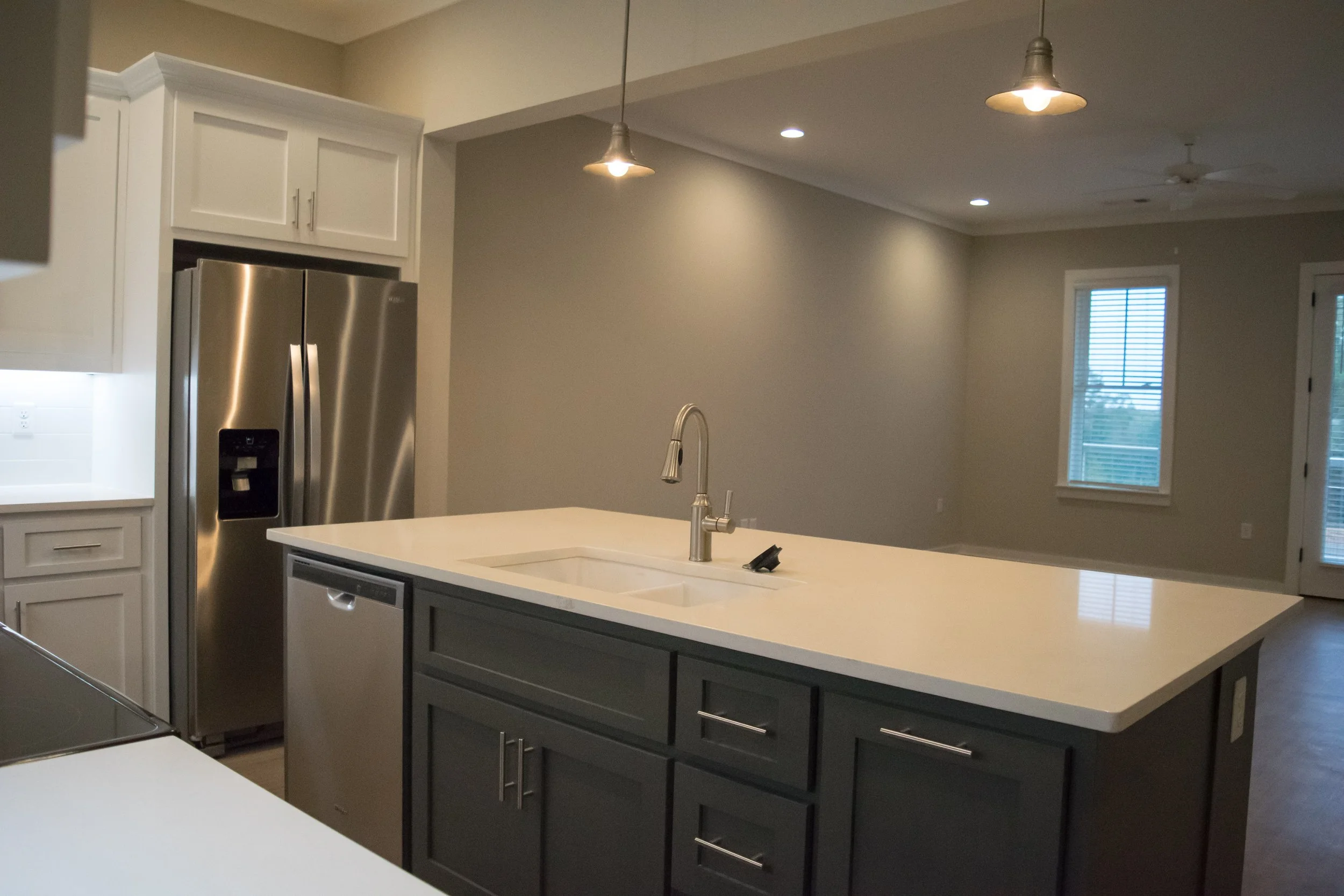 Kitchen area with island, oven and refrigerator in the Old Town Townhomes multifamily townhome complex - Columbus, GA