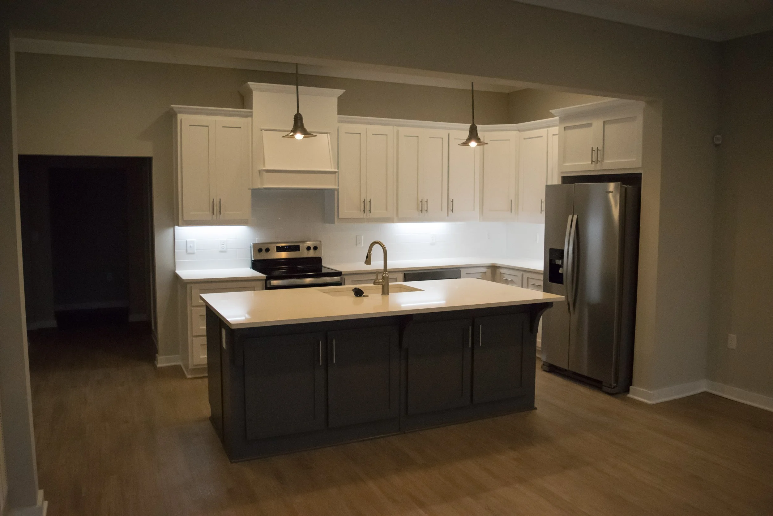 Kitchen area with island, oven and refrigerator in the Old Town Townhomes multifamily townhome complex - Columbus, GA
