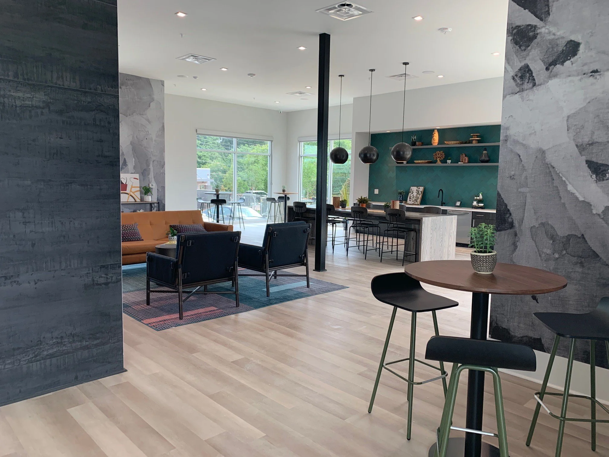 Common area with a high table and seating area in the background within The Beacon - Kennesaw, GA