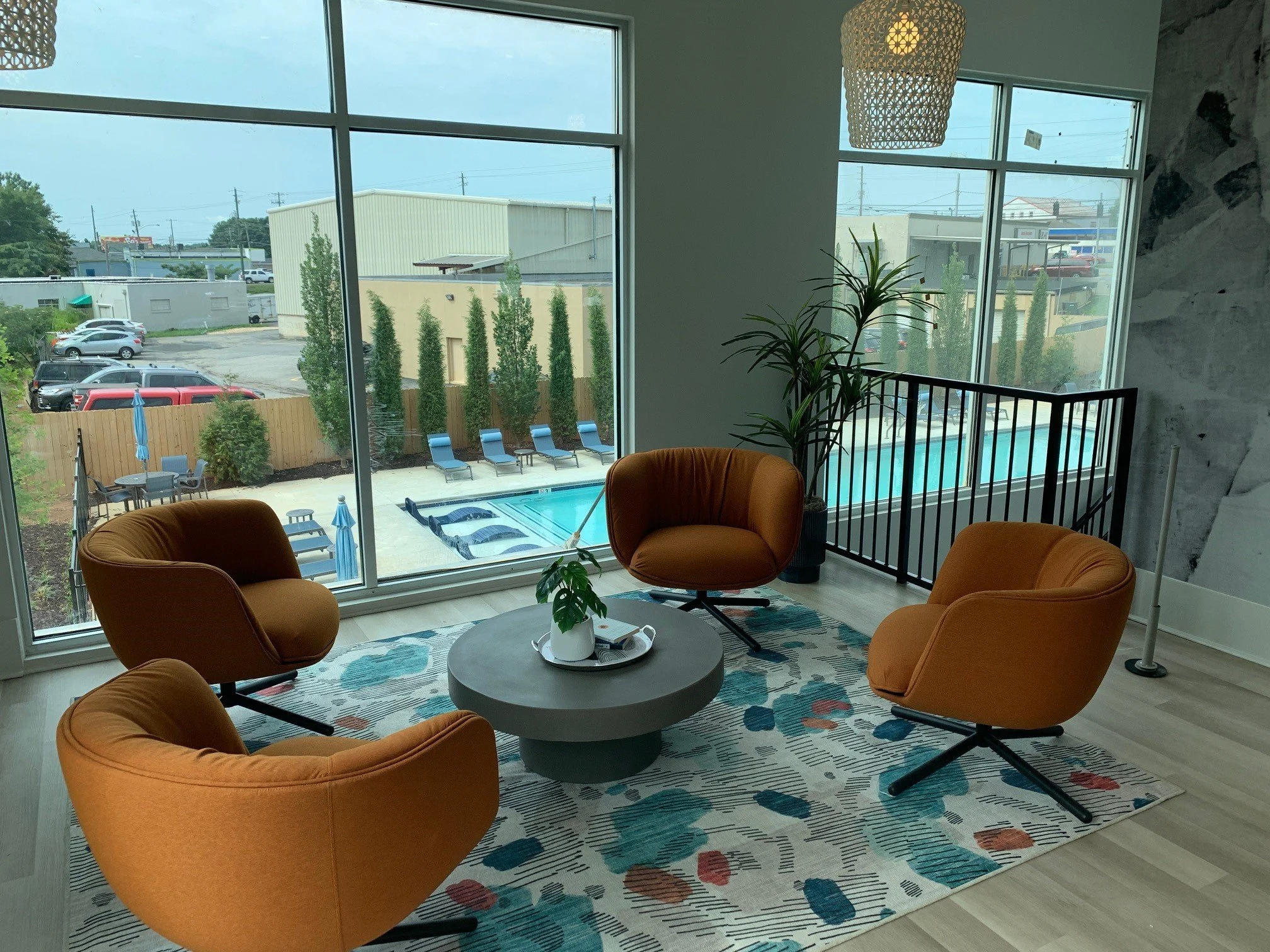 Sitting area in the commons room with a pool in the background outside located at The Beacon - Kennesaw, GA