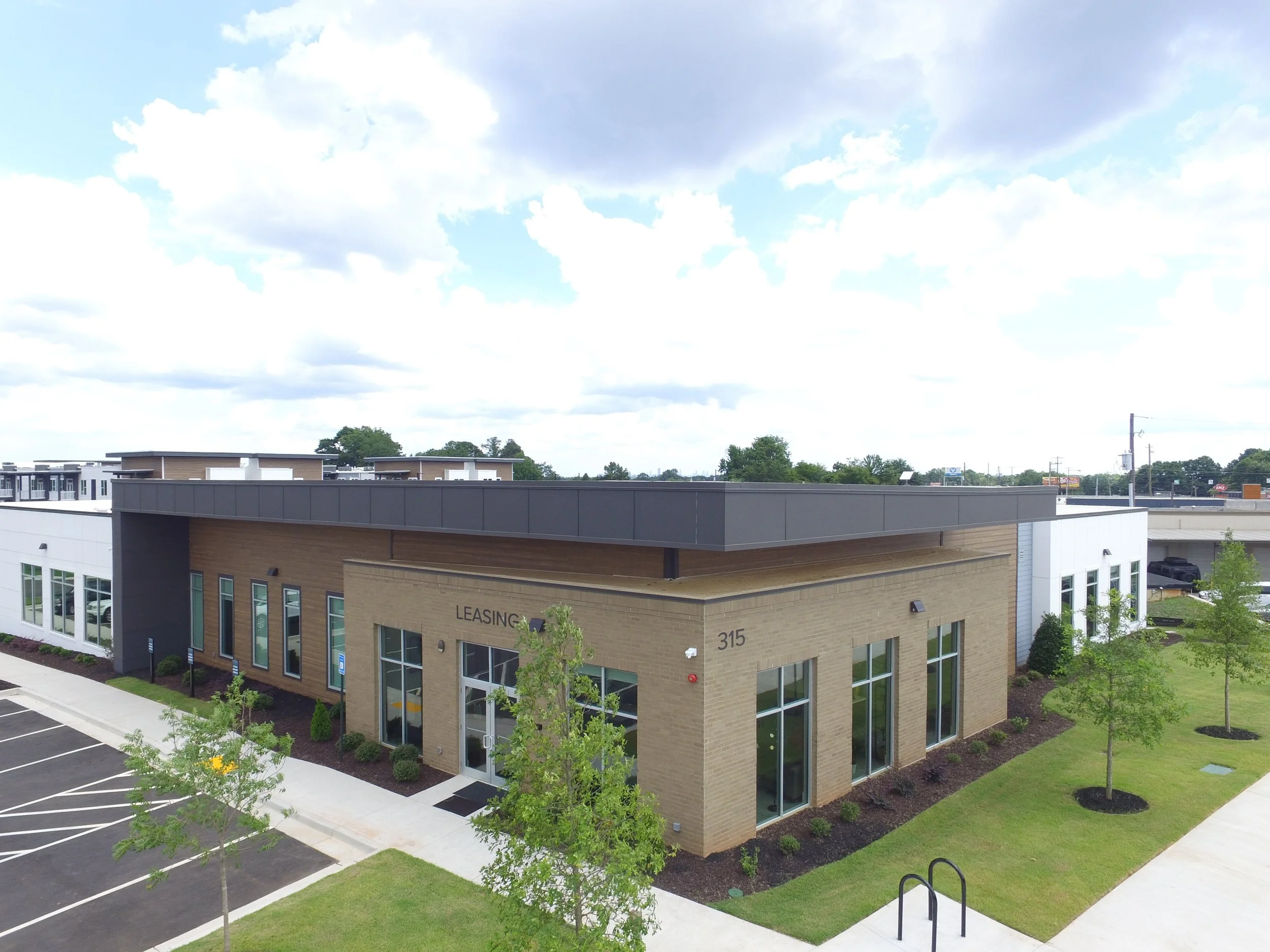 Overhead shot of the main office and the surrounding parking lot and trees at The Beacon - Kennesaw, GA