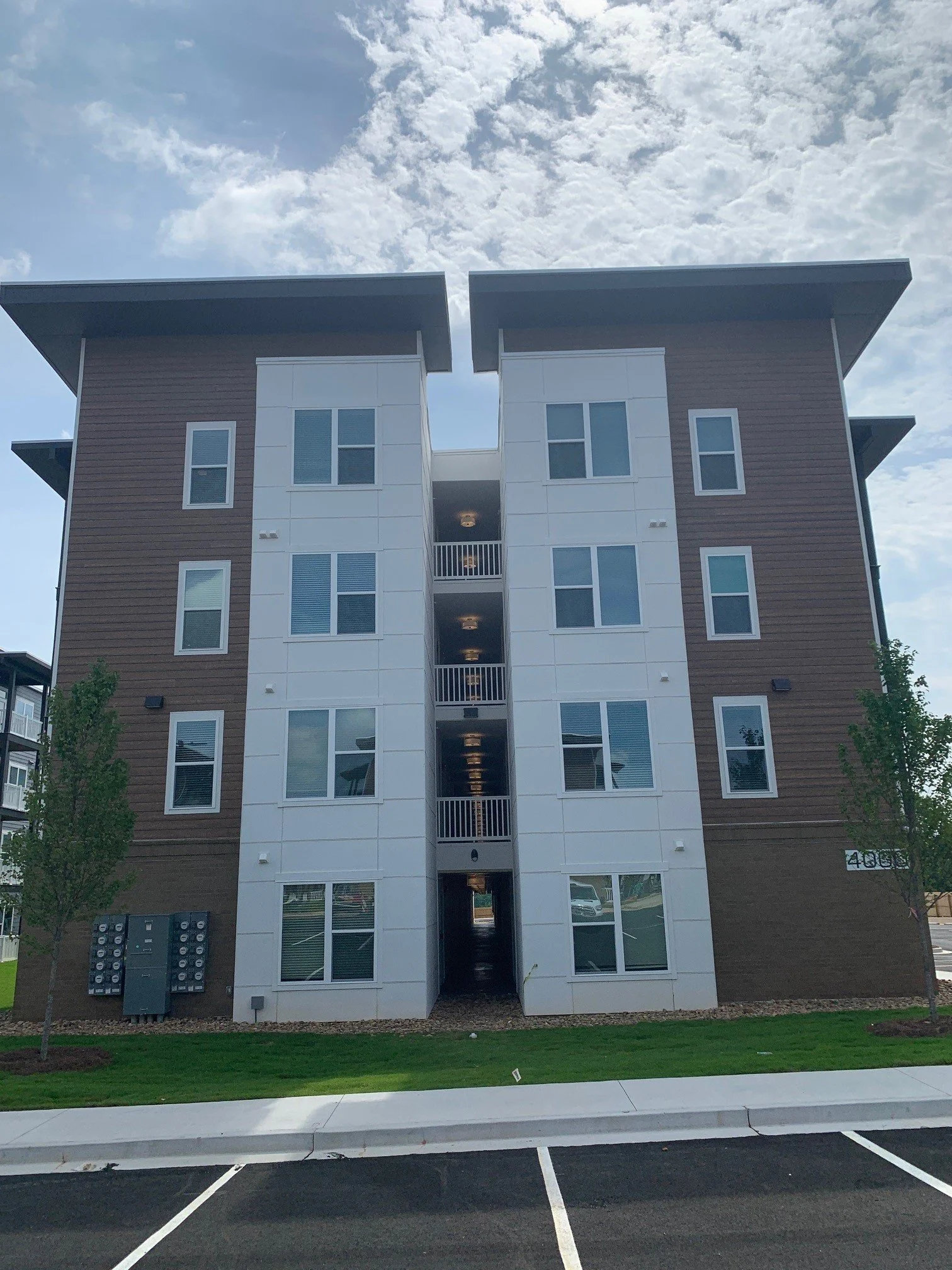 End units of a typical multifamily apartment unit with some of the parking lot seen in the foreground at The Beacon - Kennesaw, GA