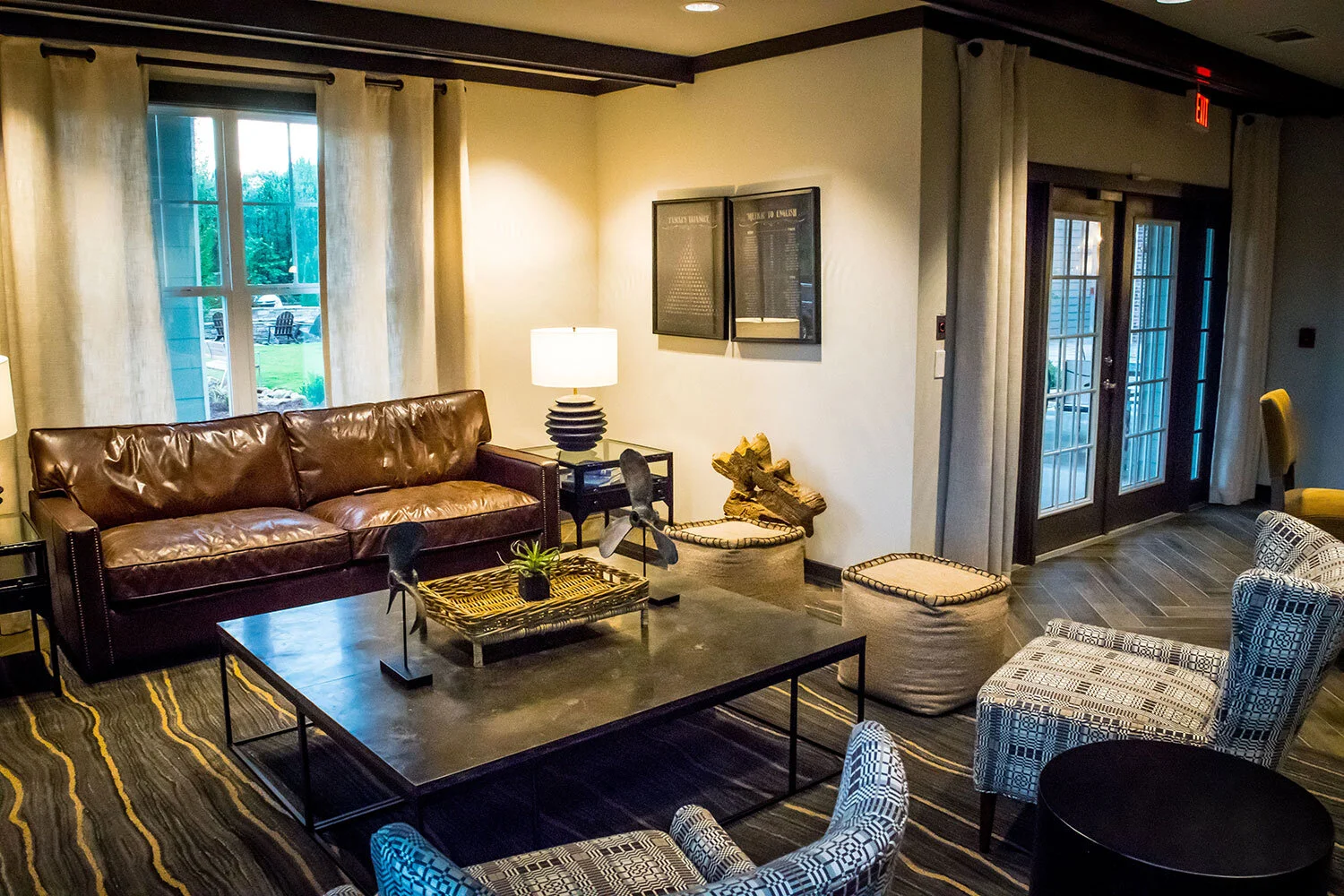 Common room with a large couch, coffee table, and various chairs at the Riverpoint - Rome, GA