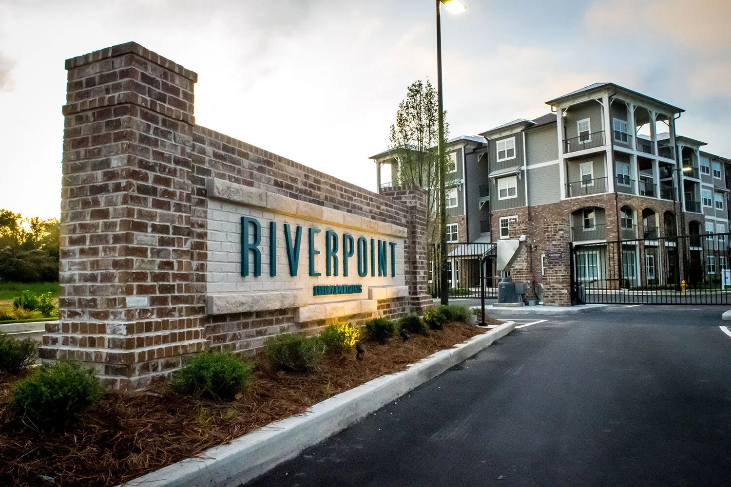 Low-angle shot of a multifamily apartment complex with signage out front at the Riverpoint - Rome, GA