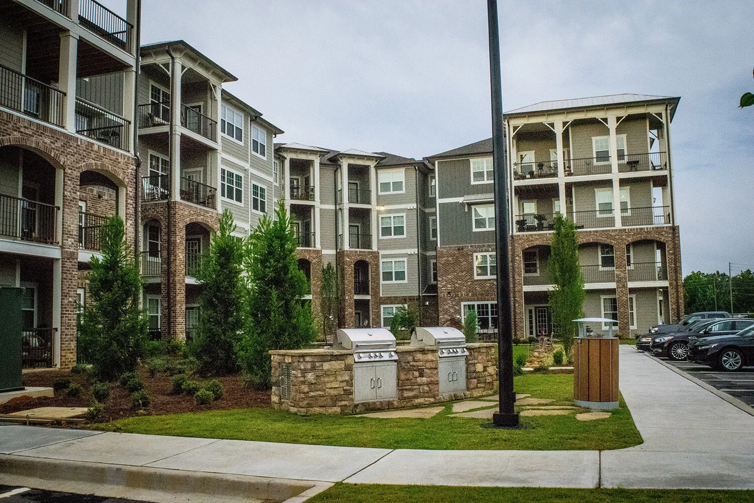Low-angle shot of multifamily apartment complex units with grills and signage out front at the Riverpoint - Rome, GA