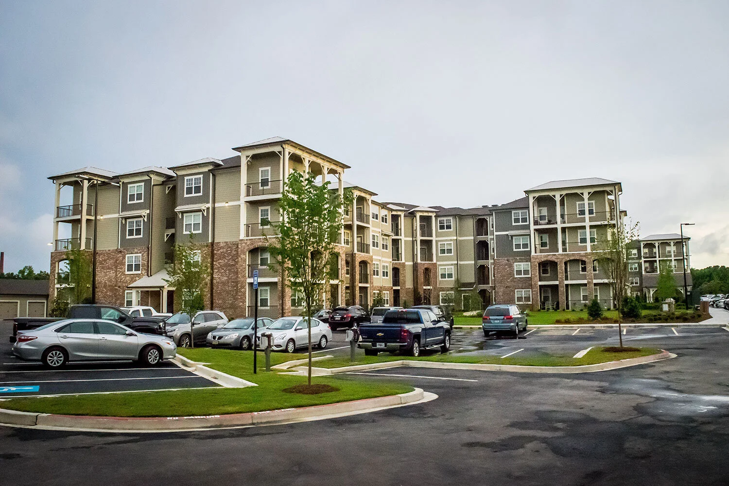 Low-angle shot of multifamily apartment complex units with parking lots and landscaping at the Riverpoint - Rome, GA