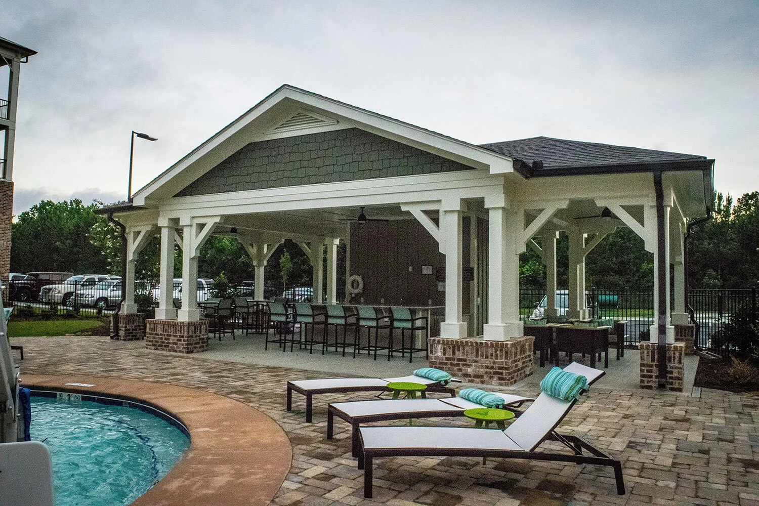 Cabana with tables in chairs next to a pool and lounging chairs at the Riverpoint - Rome, GA