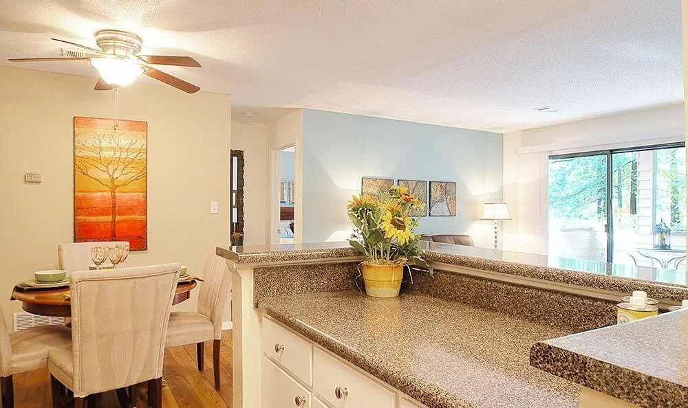Kitchen countertops with a dining table and chairs in the background at the Reserve at Peachtree Corners - Norcross, GA