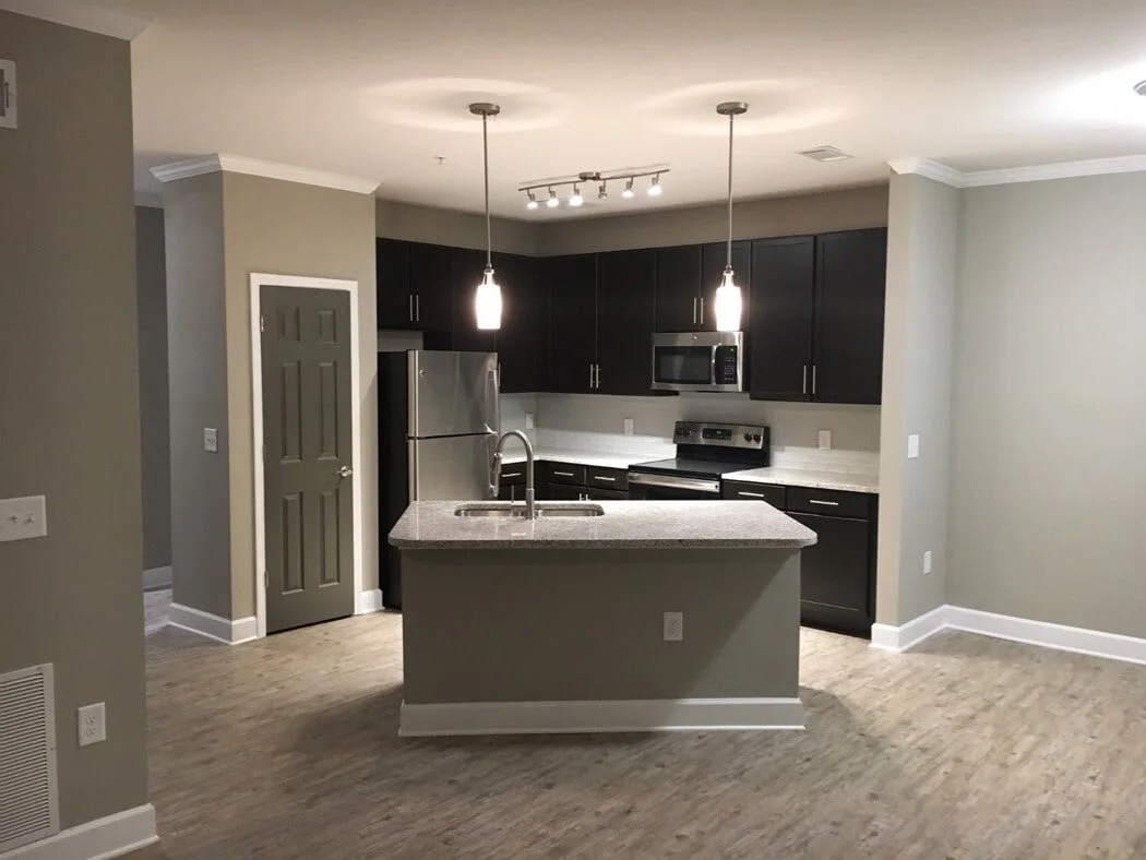 Typical kitchen with island located within a multifamily apartment building at Harbor Creek - Canton, GA