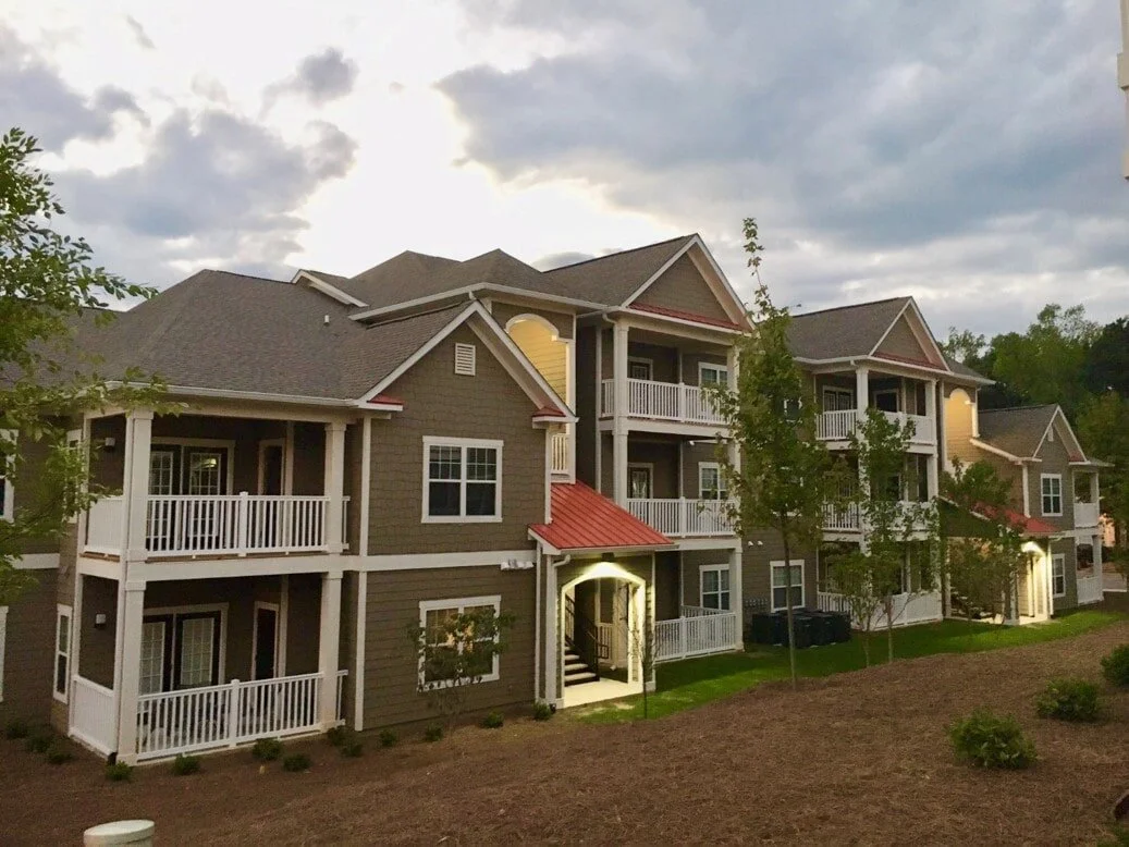 Outdoor shot of a multifamily apartment building with entrances and balconies at Harbor Creek - Canton, GA