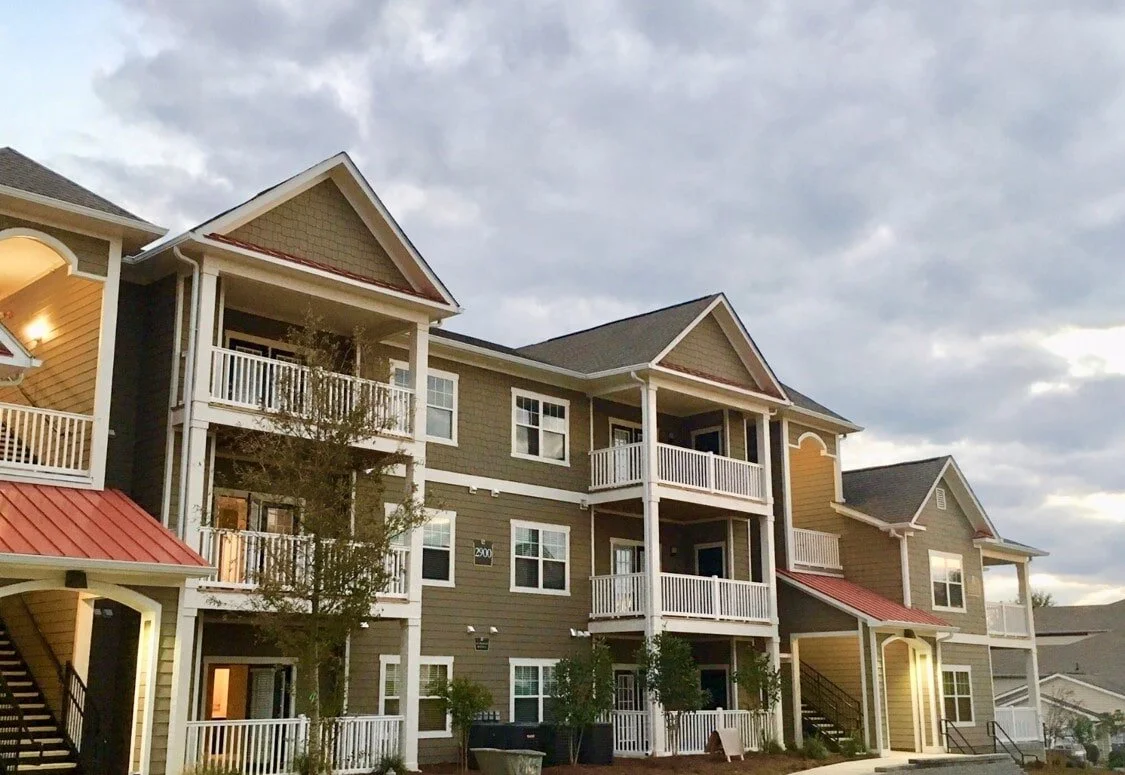 Outdoor shot of a multifamily apartment building with entrances and balconies at Harbor Creek - Canton, GA