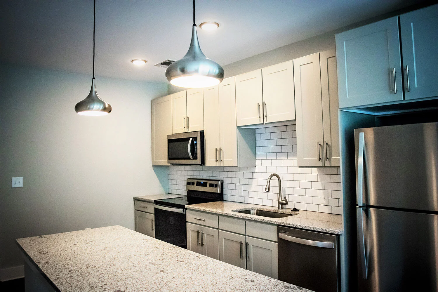 Kitchen, various appliances, and prep station in a typical multifamily complex unit at City of Refuge - Atlanta, GA