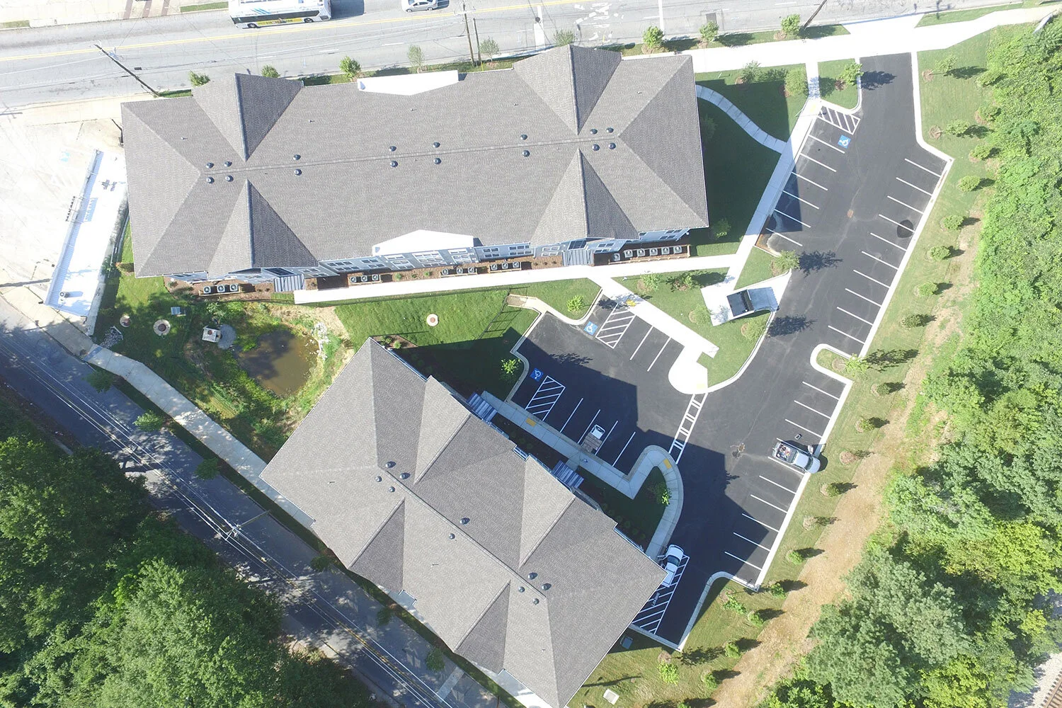 Overhead shot of several multifamily apartment buildings, parking lots, and landscaping at City of Refuge - Atlanta, GA
