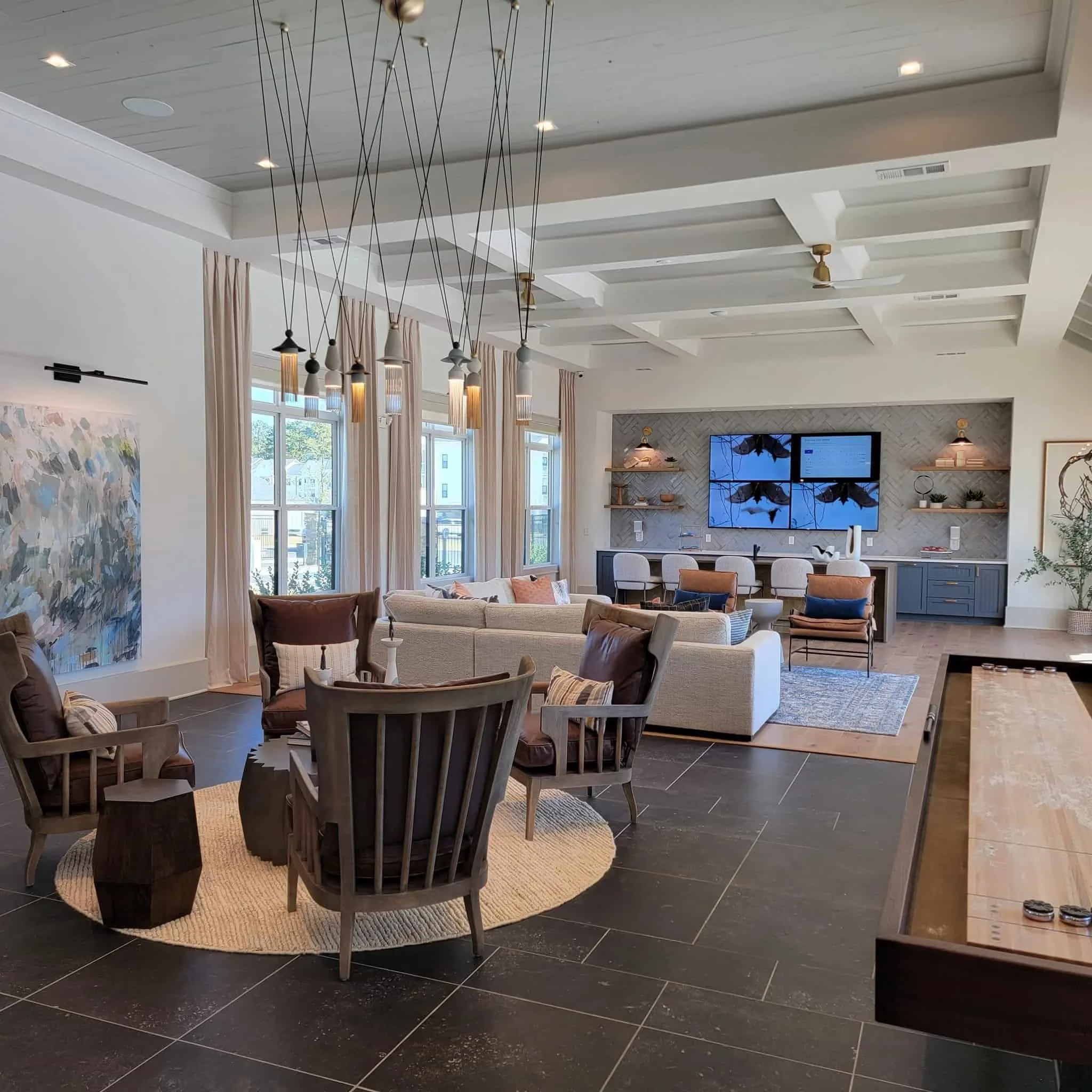 Interior common area lounge with TVs on the wall.