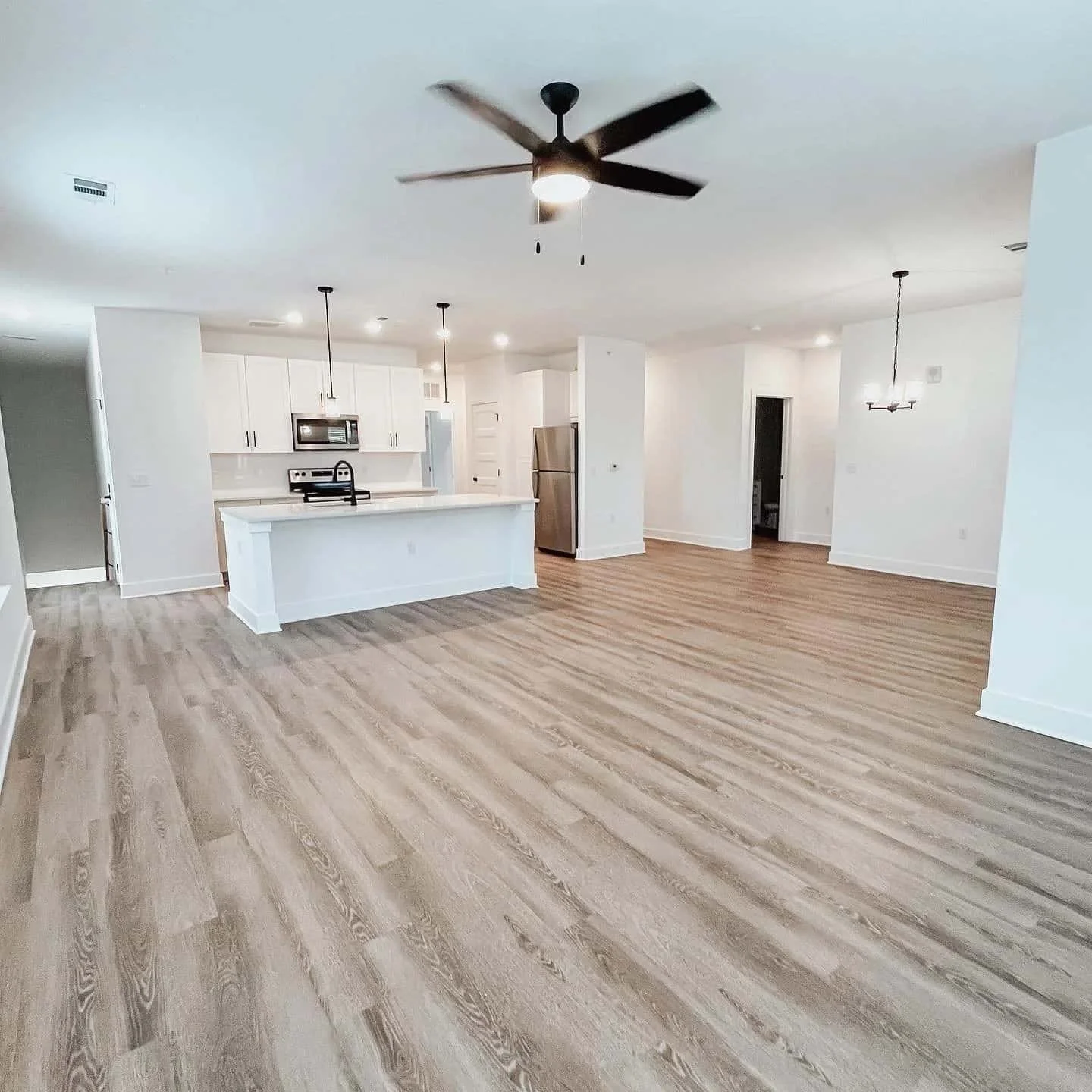 Living area with white walls and wood floor.