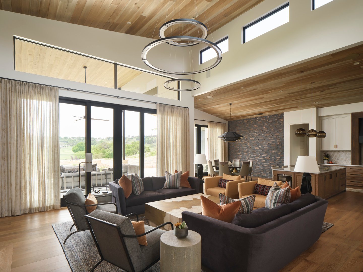 A seamless blend of indoors and out.

Expansive windows and a wood ceiling detail carried inside create a strong connection to the landscape. The rich furnishings palette and warm wood tones create a bold, but balanced space that is modern and earthy