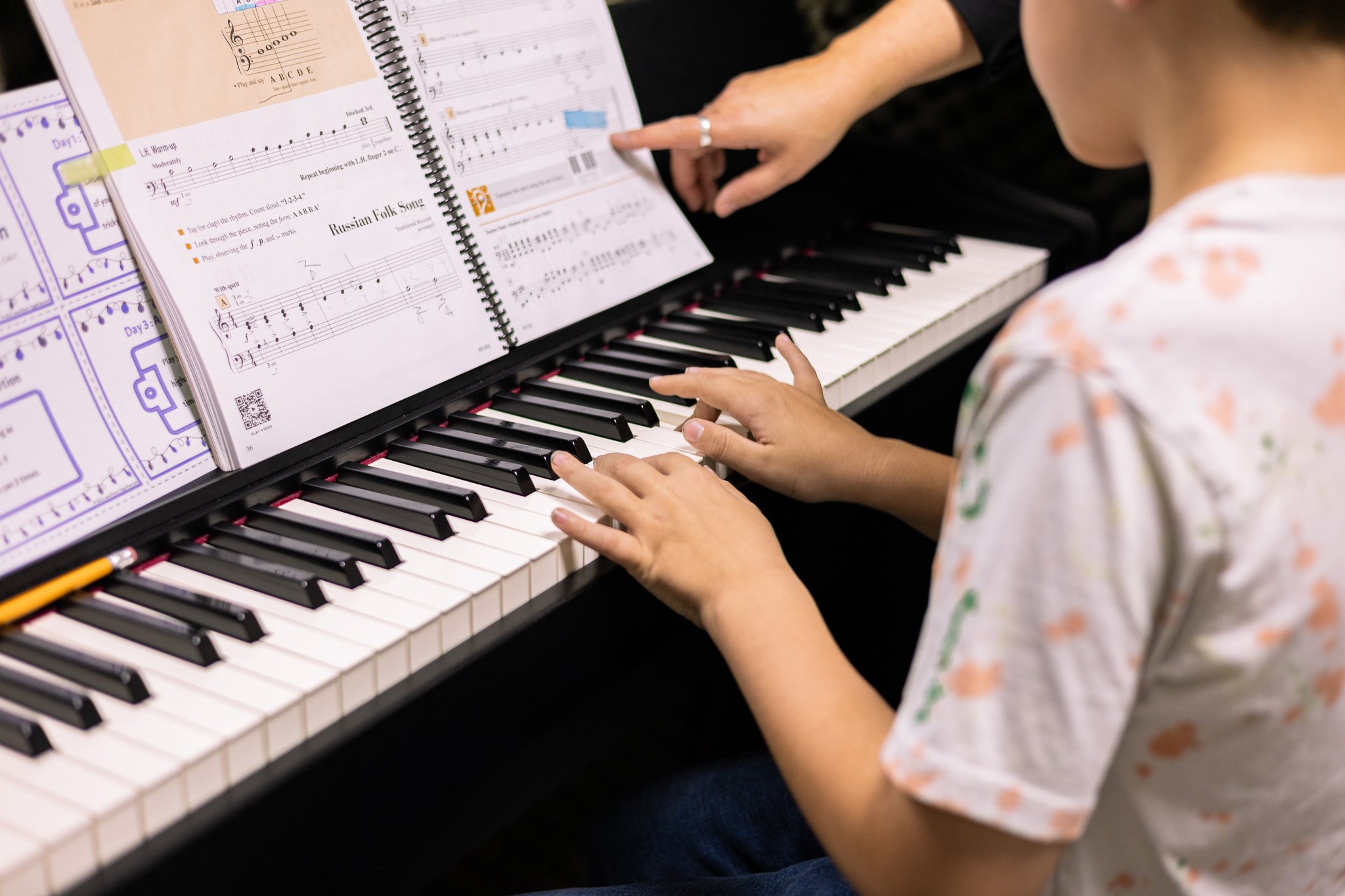 child playing piano with teacher