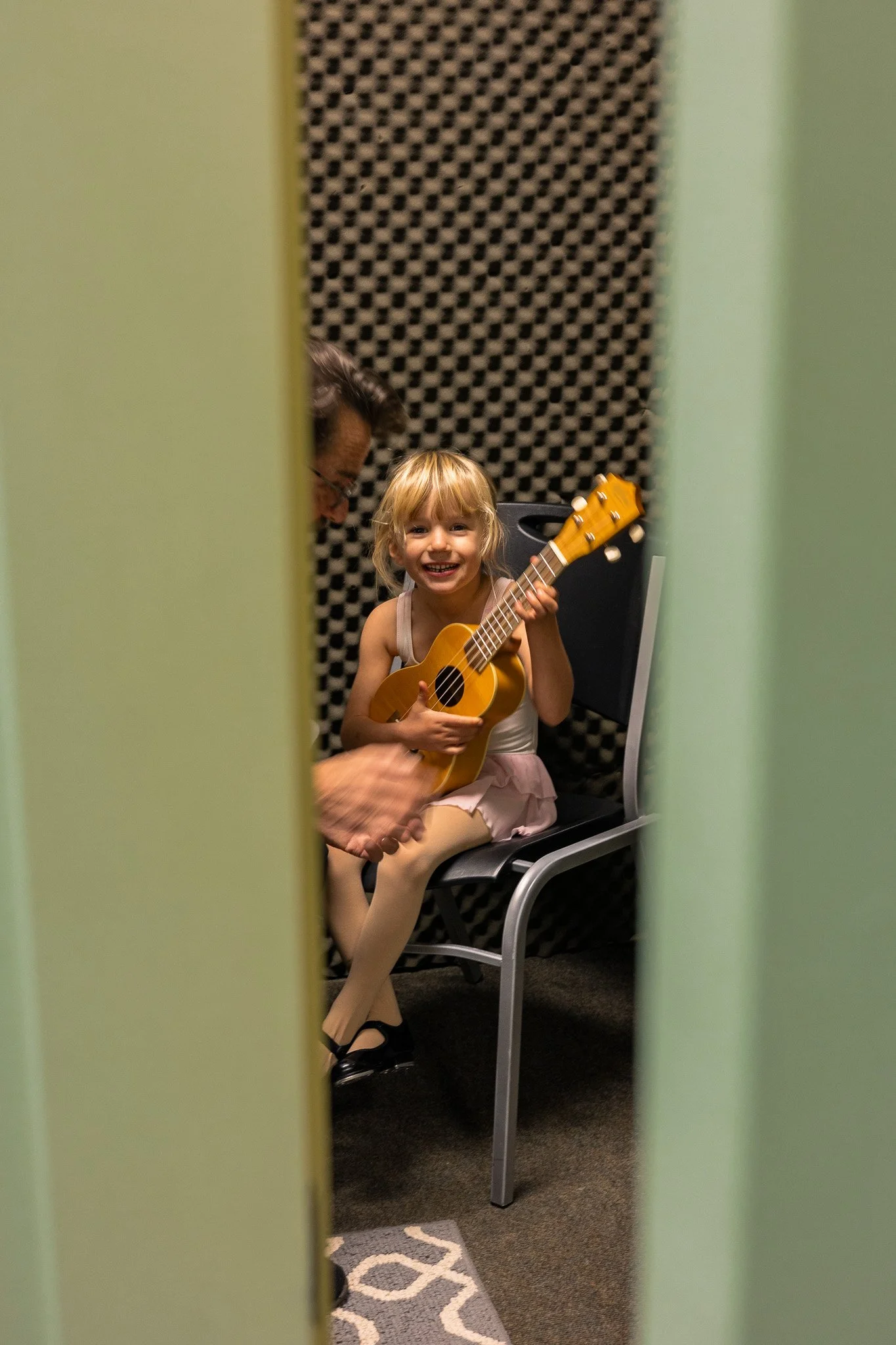 girl learning ukulele with instructor