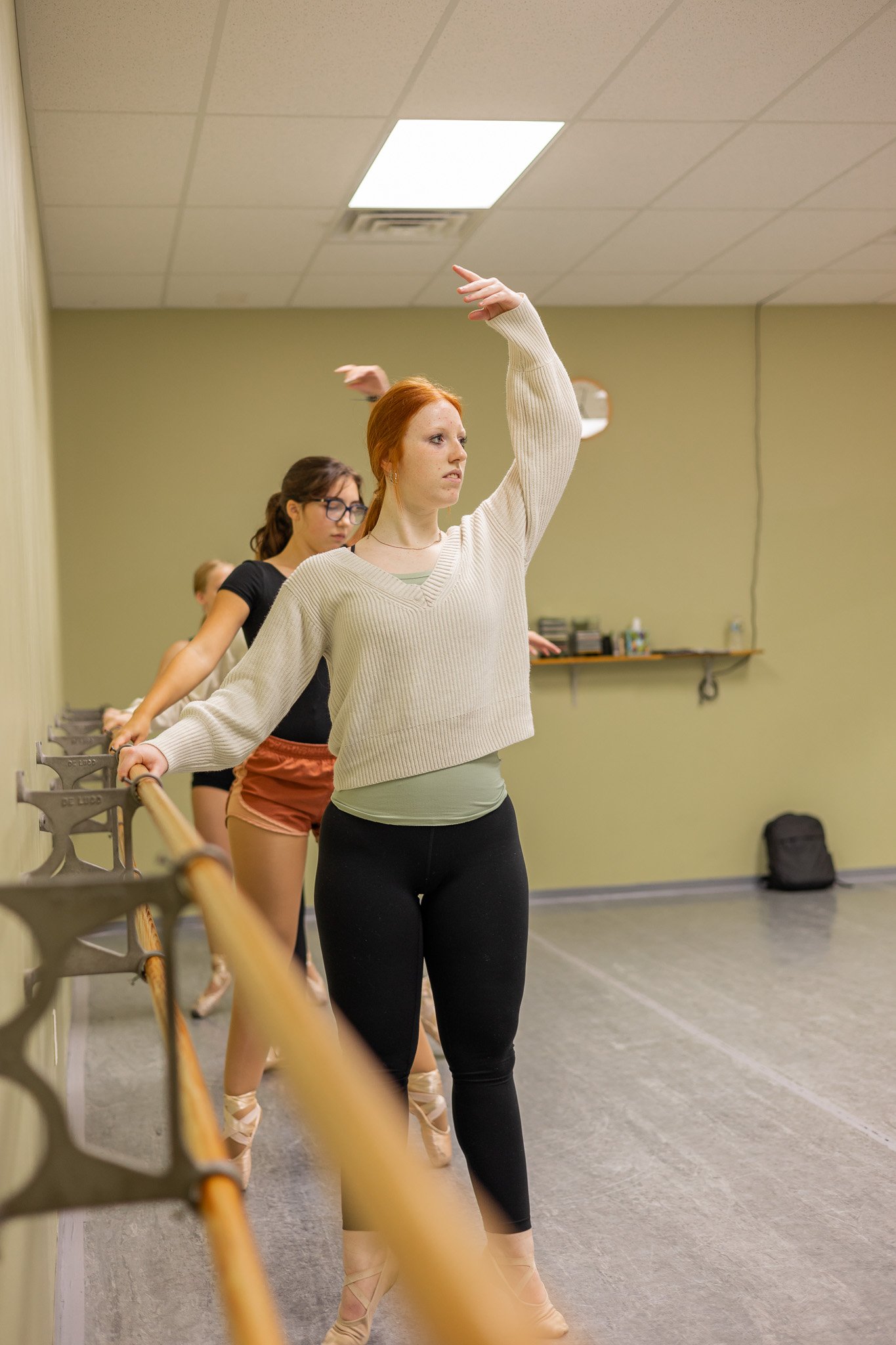 girls warming up at barre in dance class