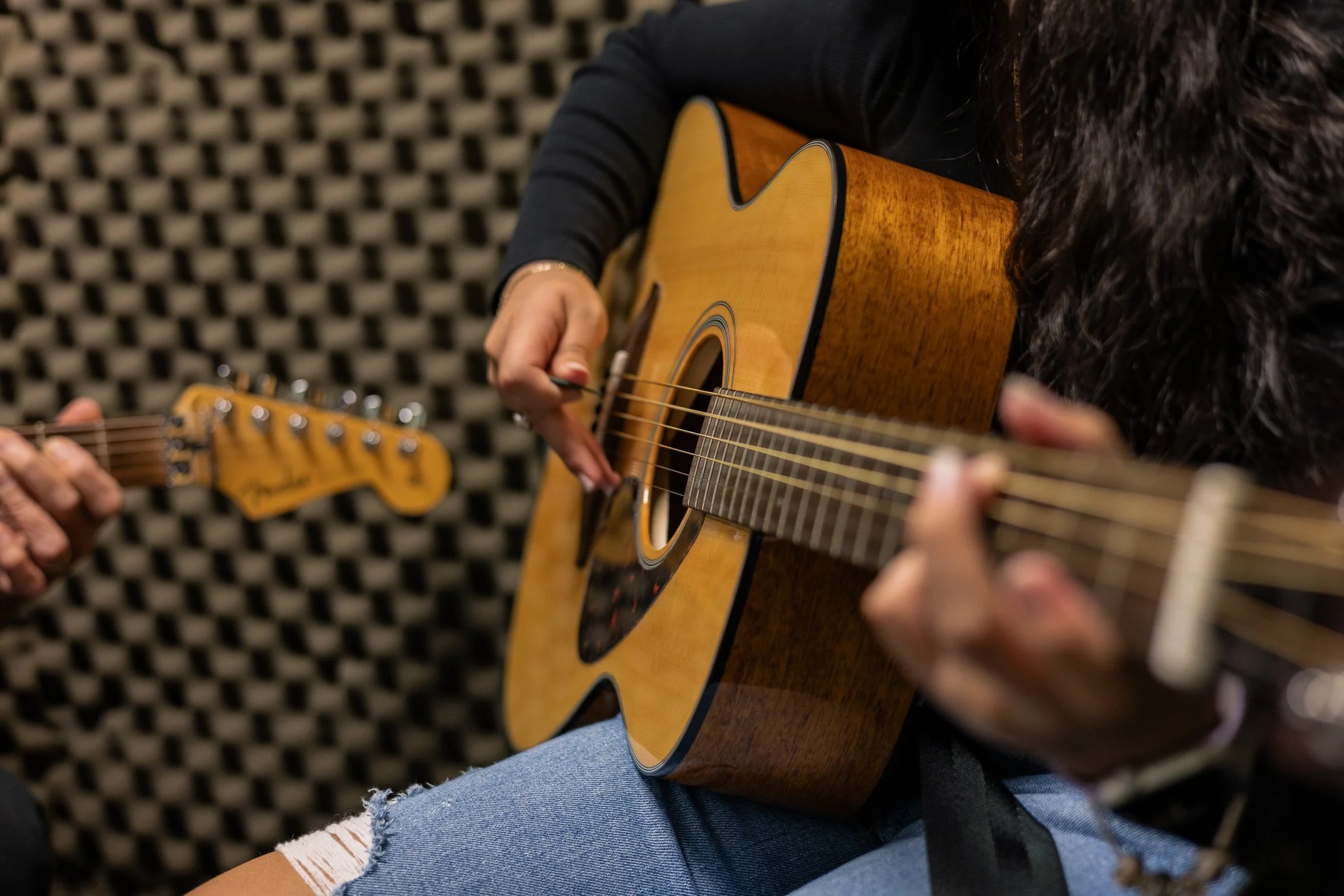 teenage girl holding guitar in guitar lesson