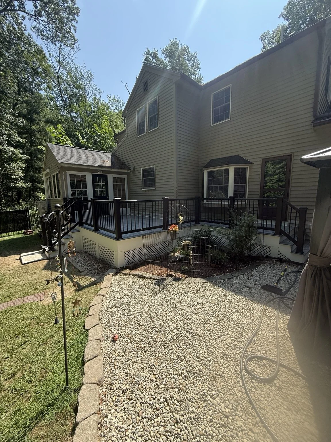 Completed composite deck with black railings, stairs, PVC trim and lattice by King Construction.