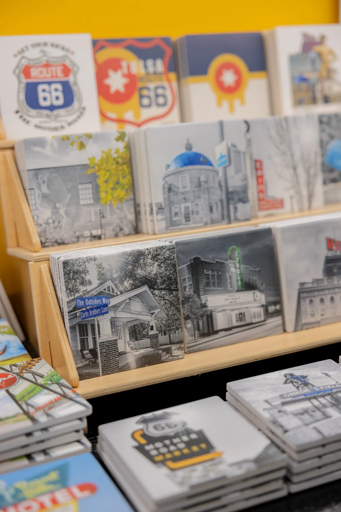 Shelf displaying various postcards and greeting cards with images of buildings, signs, and landmarks, some in black and white.