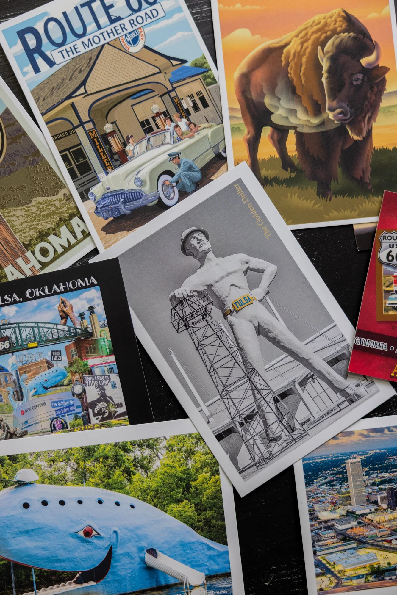 A collage of various illustrations and photographs, including a vintage Route 66 sign pointing to 'The Mother Road,' a bison grazing in a sunset landscape, a black and white photo of a man with a 'Tulsa' statue, a colorful Tulsa cityscape, a large wh