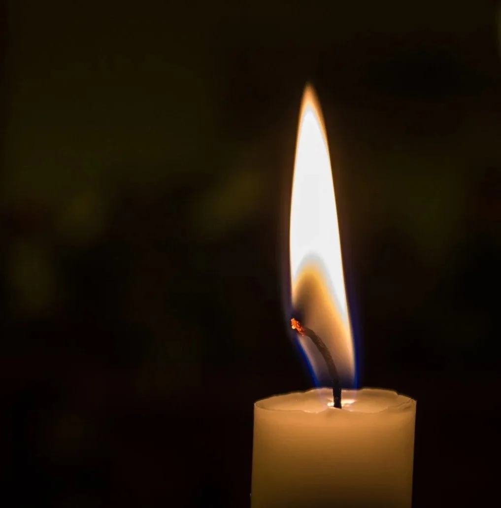 A lit candle symbolizing reflection, hope, and the Inner Light in Quaker worship.
