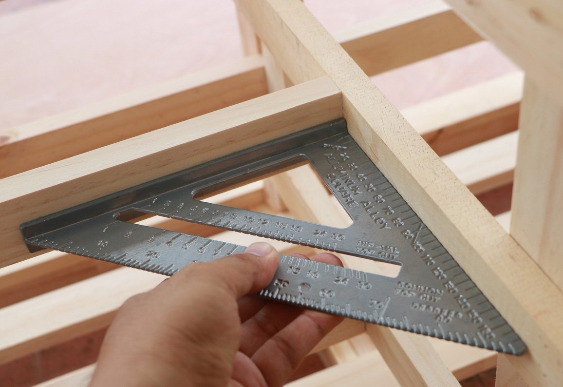 Carpenter's square measuring a wooden frame, symbolizing the Quaker testimony of integrity and living truthfully.