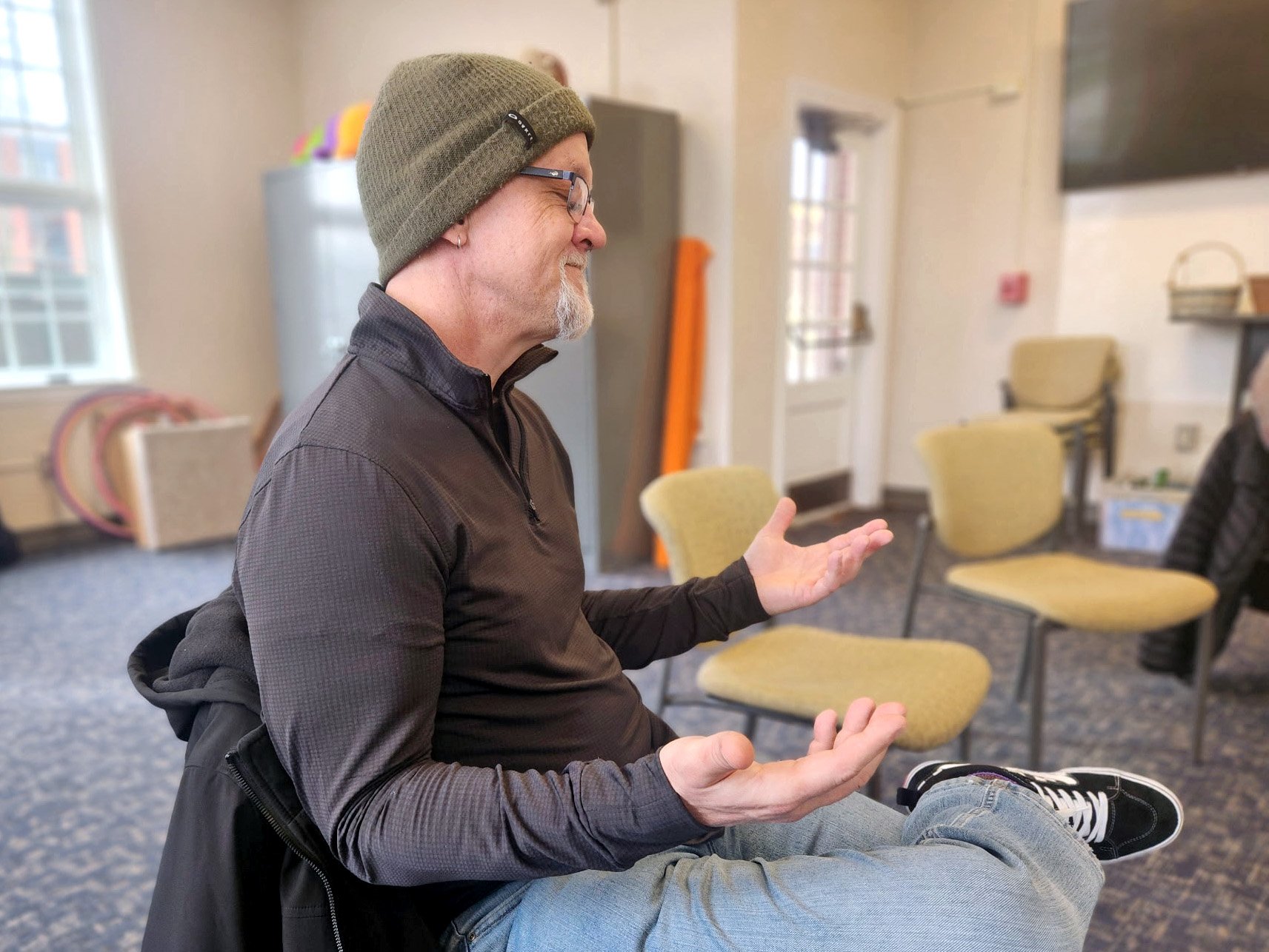 Person sitting quietly with open hands in a posture of prayer and reflection during a Quaker meditation at Holland Friends Meeting.