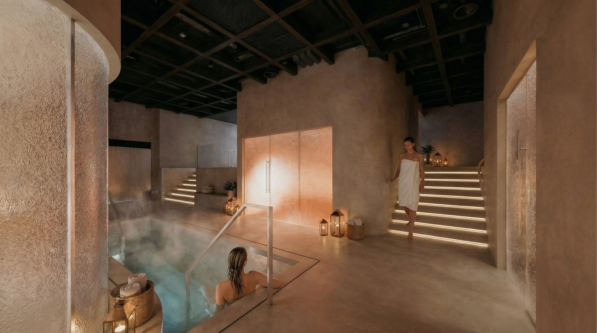 Indoor spa room with a person relaxing in a hot tub and a woman standing on illuminated stairs wrapped in a towel, with warm ambient lighting and candles.