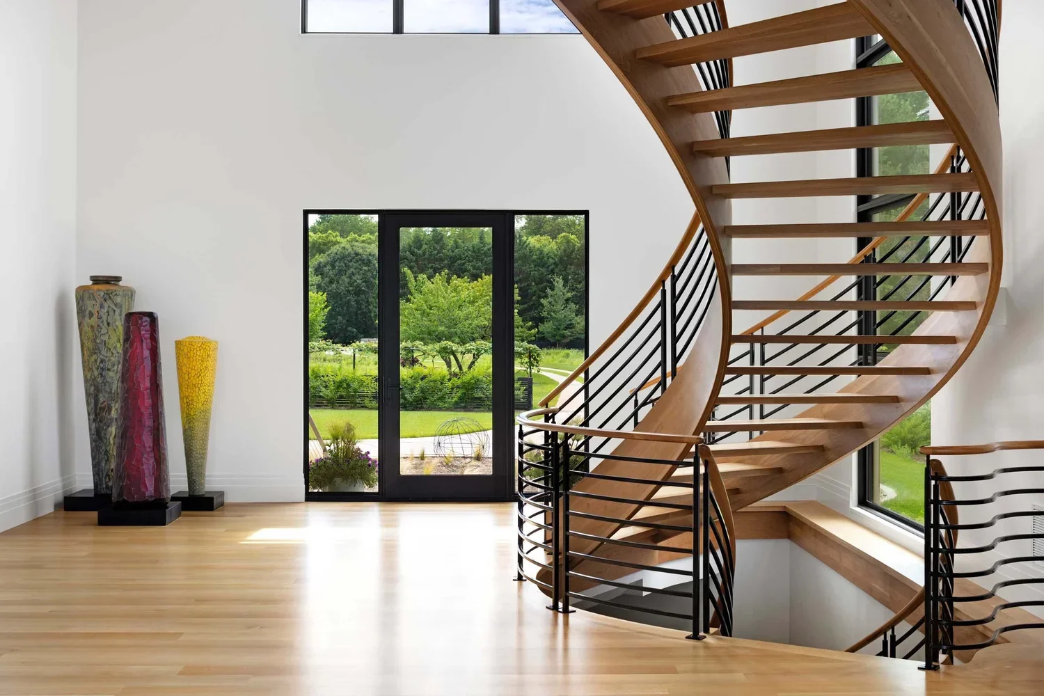 tidewater-modern-house-modern-home-entrance-foyer-curved-staircase-annapolis-md-kimmel-architects.webp