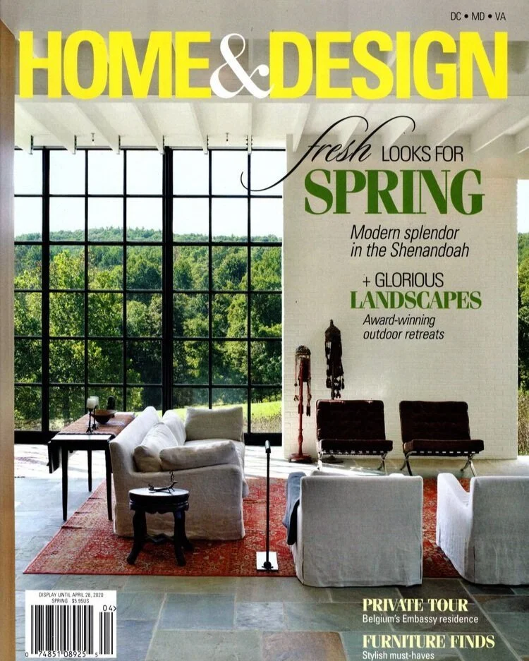Kimmel Studio Architects Cover of Home & Design magazine featuring a modern living room with large glass windows overlooking a green outdoor landscape, white and dark furniture, and decor for spring.